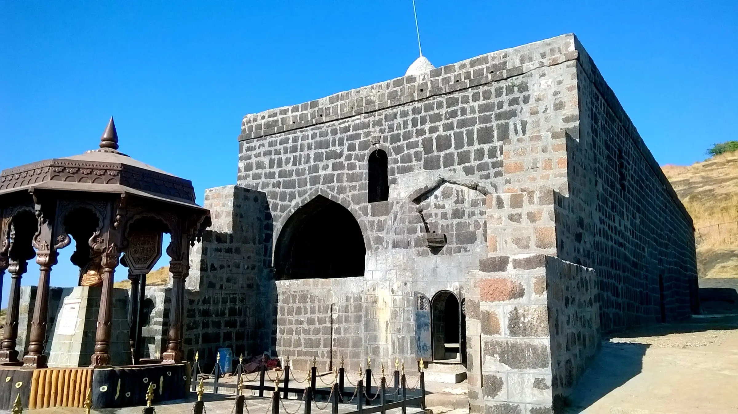 The restored stone Ambarkhana hall on Patta Fort with the ornate meghadambari canopy beside it
