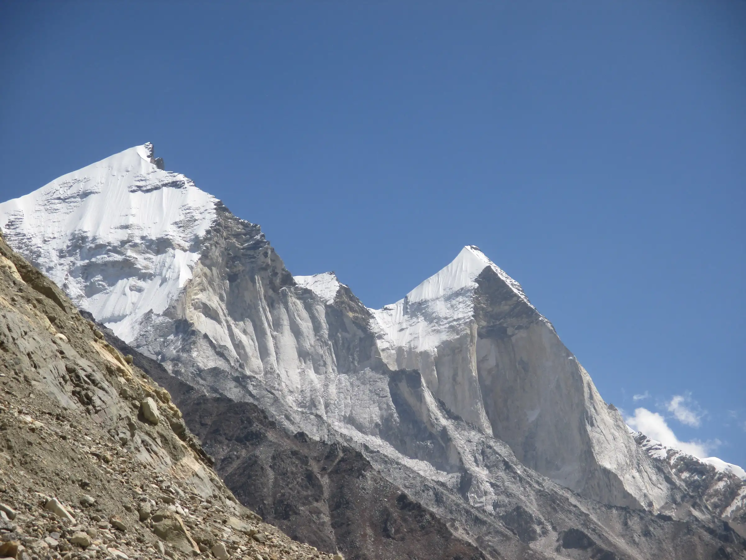The snow-capped granite walls of Bhagirathi II and III against a deep blue sky, seen from the moraine on the way into Nandanvan