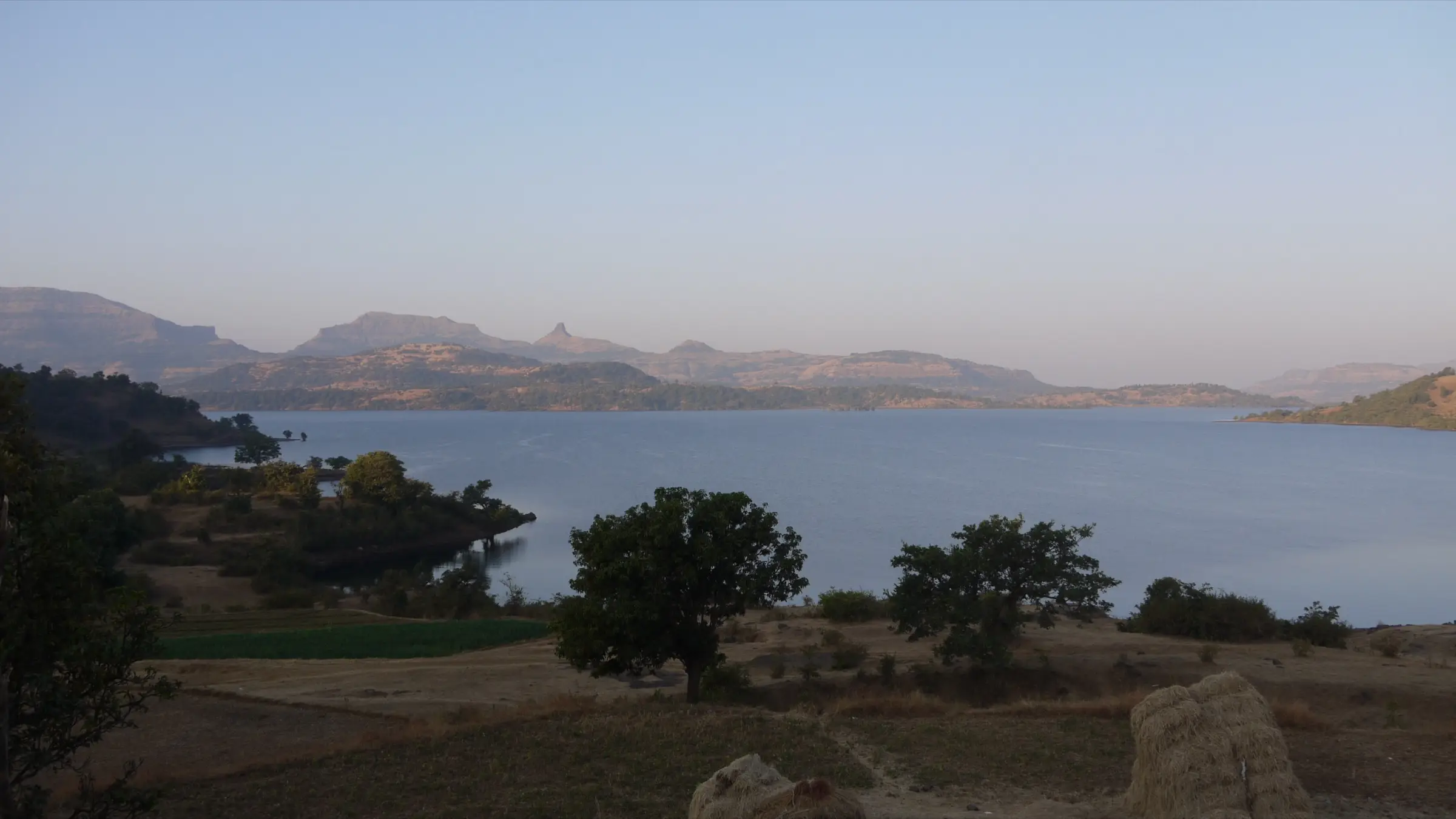 Bhandardara lake with Sahyadri ridges and pinnacles behind it, in the hills north of the trek (not the trek itself)