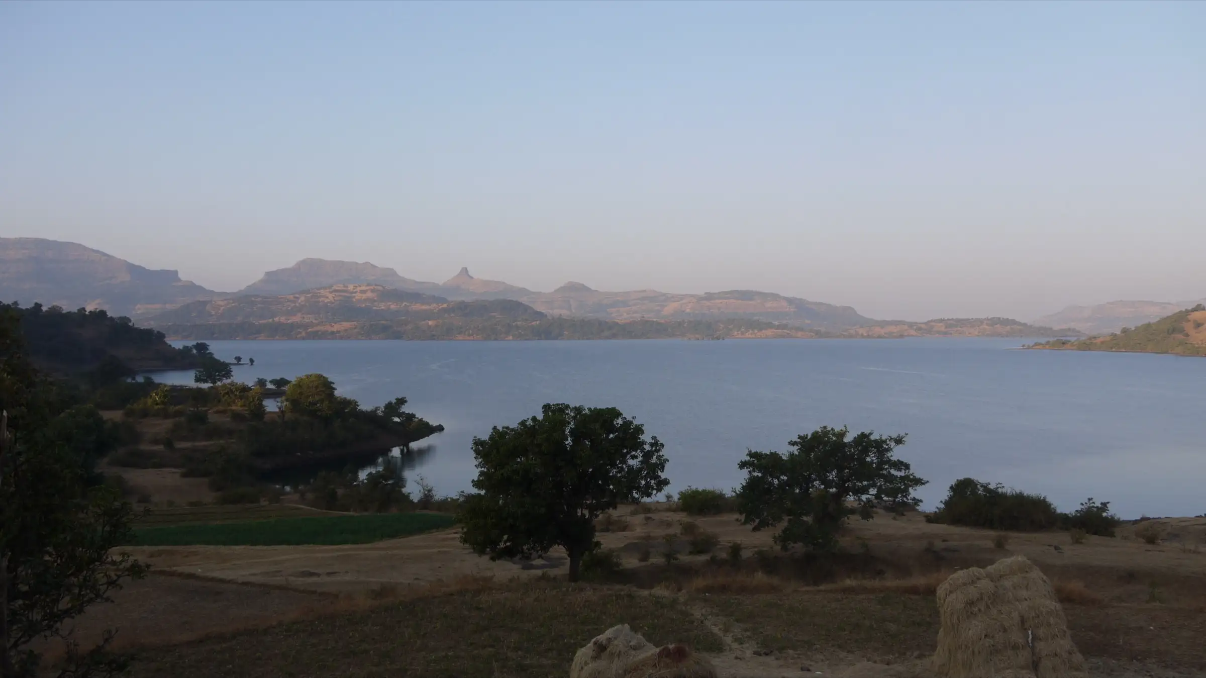 Bhandardara lake with Sahyadri ridges and pinnacles behind it, in the hills north of the trek (not the trek itself)