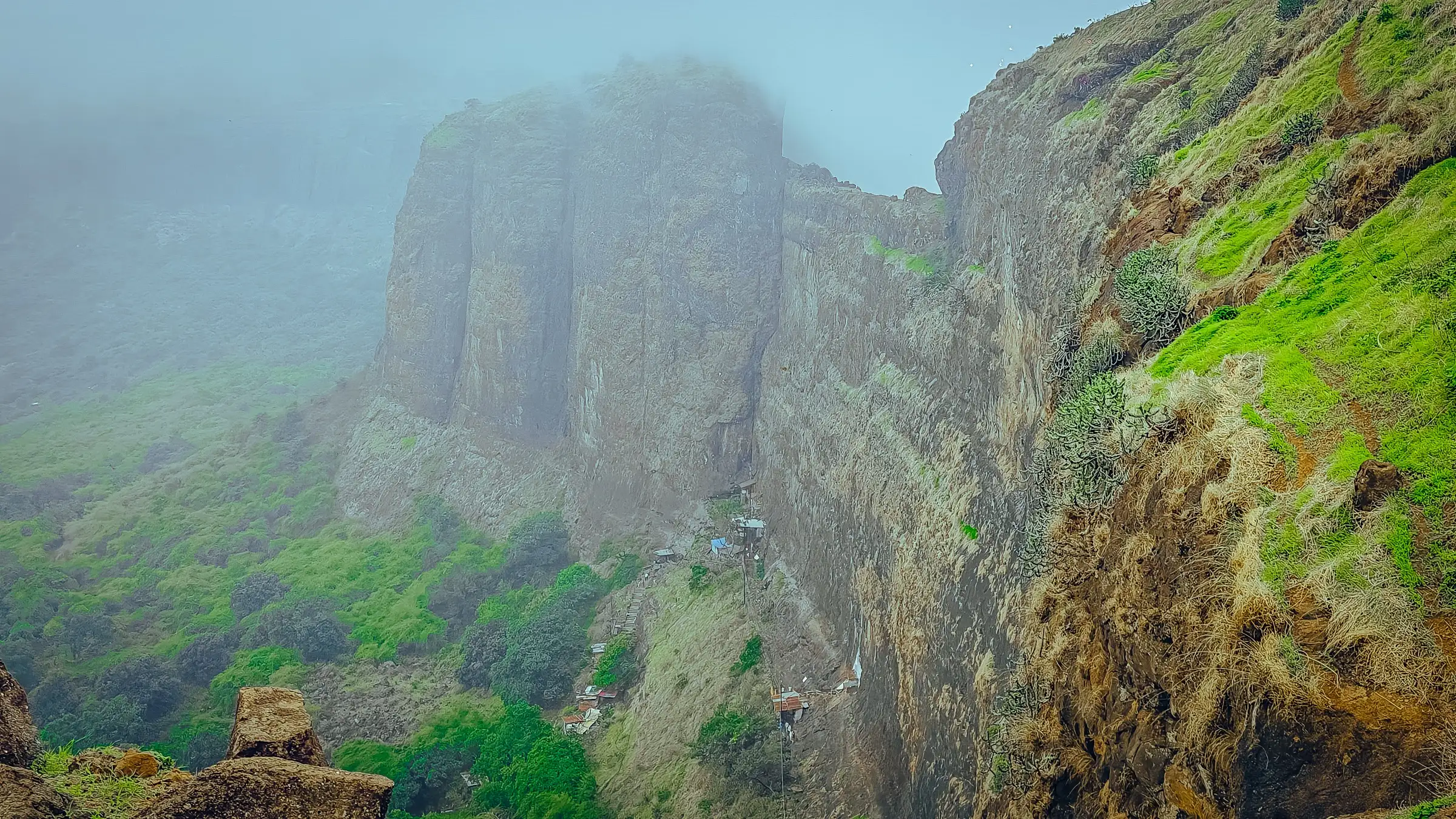Mist-wrapped basalt cliffs of Bhandardurg on the Brahmagiri ridge above green monsoon slopes