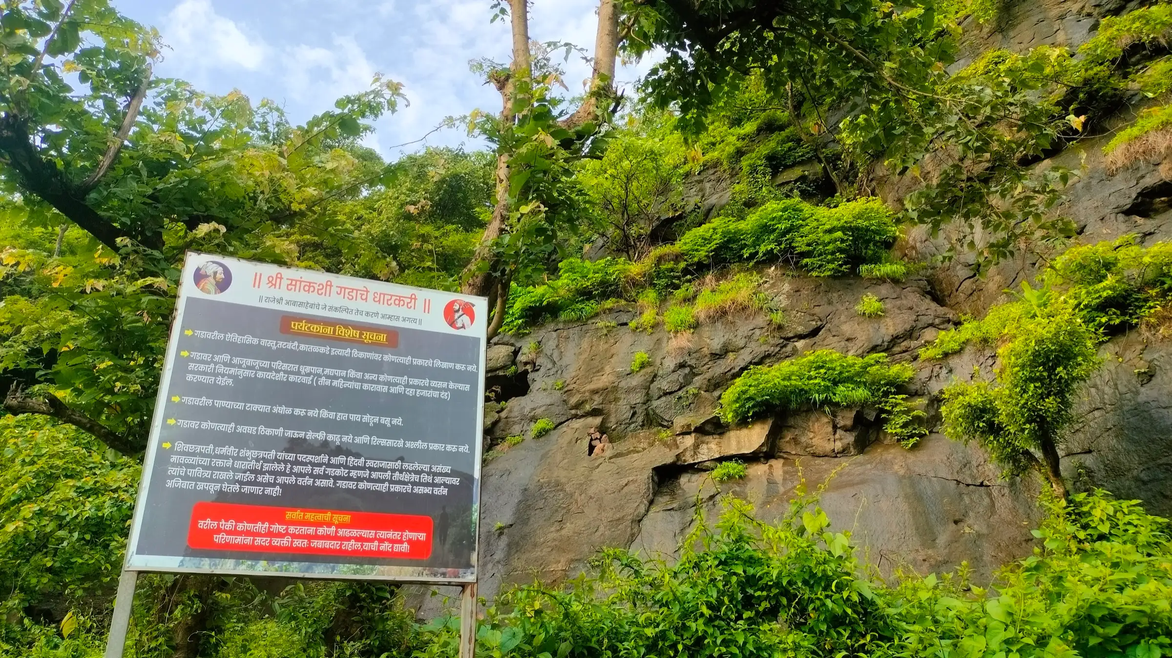 Marathi notice board with rules for visitors below the rock face of Sankshi Fort