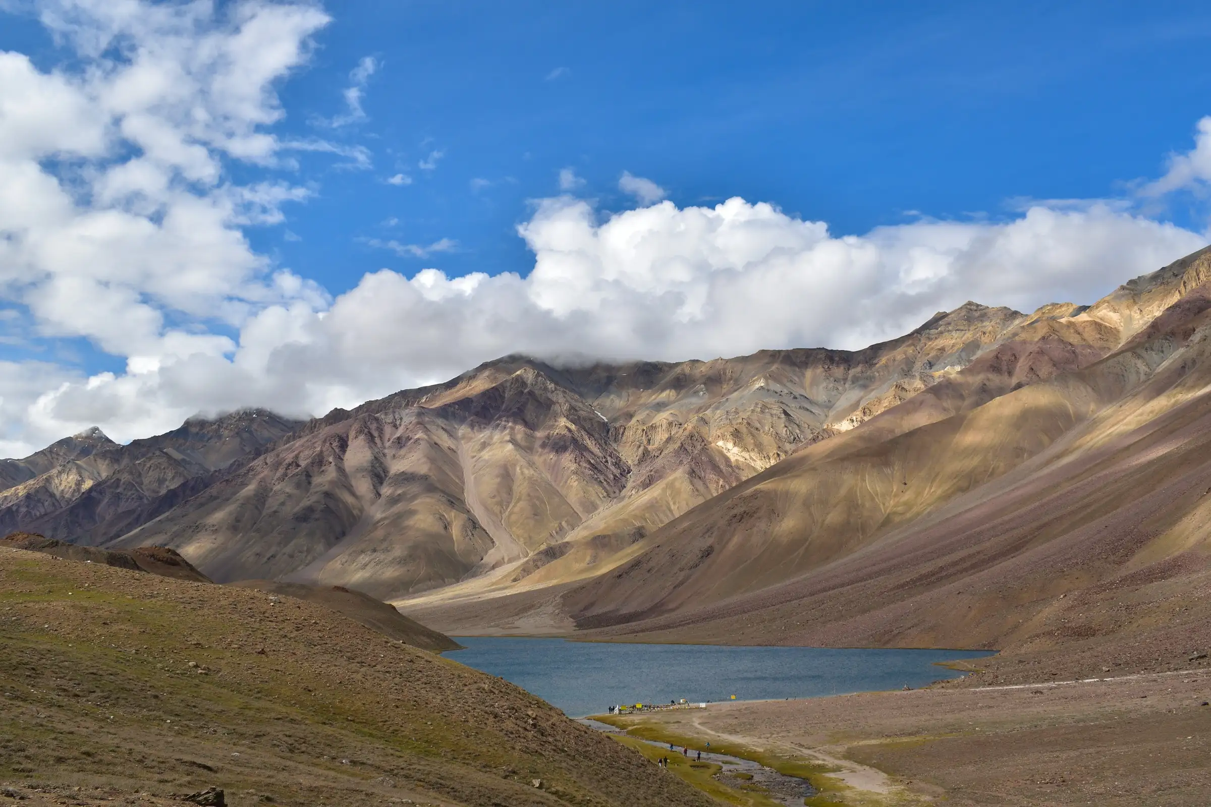 Chandratal lake below brown, cloud-capped mountains in Lahaul and Spiti, where the trek to Baralacha La begins