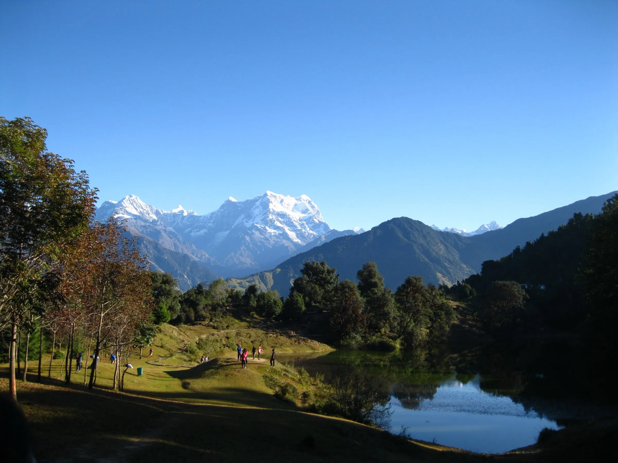 Snow-covered Chaukhamba massif above forested ridges and the Deoriatal lake meadow, the first camp on the Bisurital trek