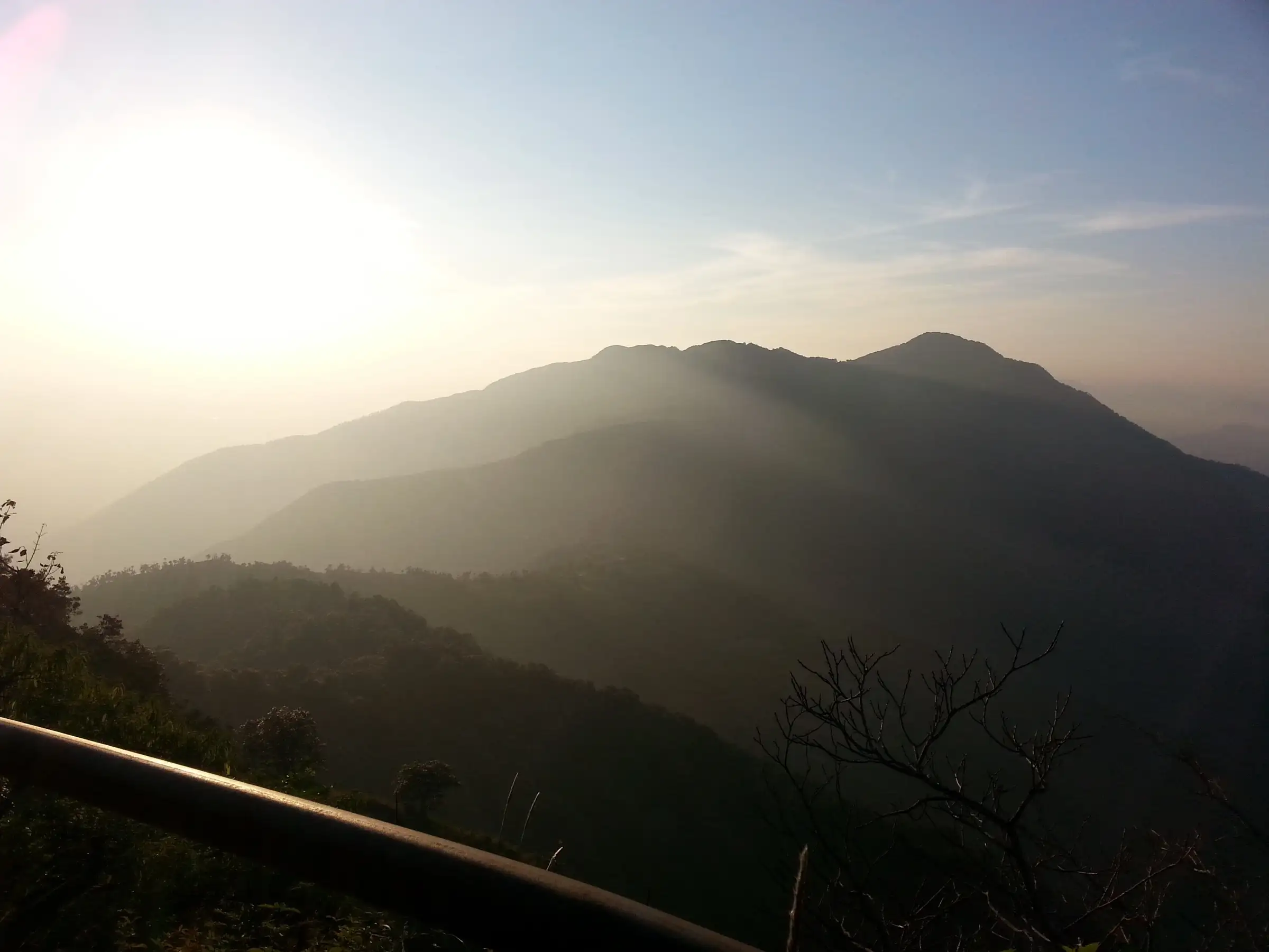 Hazy sunset over forested ridges seen from near Cloud End Forest Resort, the start of the Benog Tibba trail