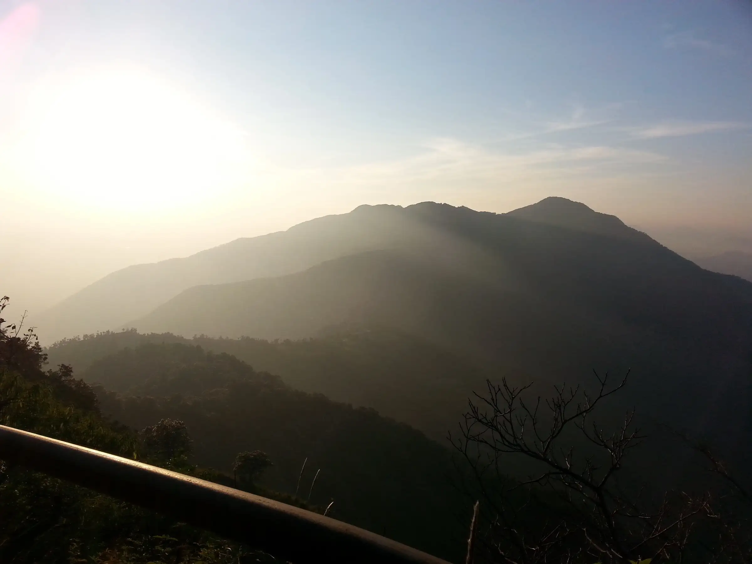 Hazy sunset over forested ridges seen from near Cloud End Forest Resort, the start of the Benog Tibba trail