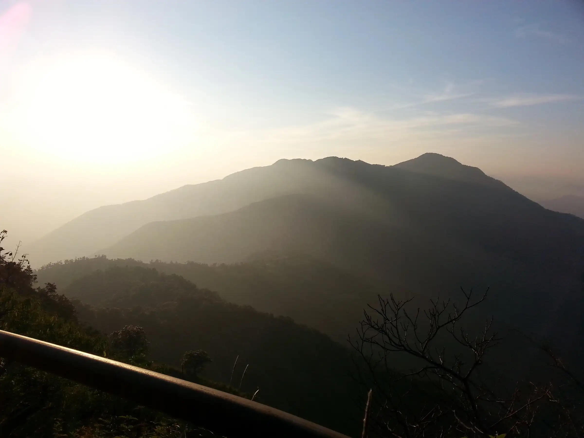 Hazy sunset over forested ridges seen from near Cloud End Forest Resort, the start of the Benog Tibba trail