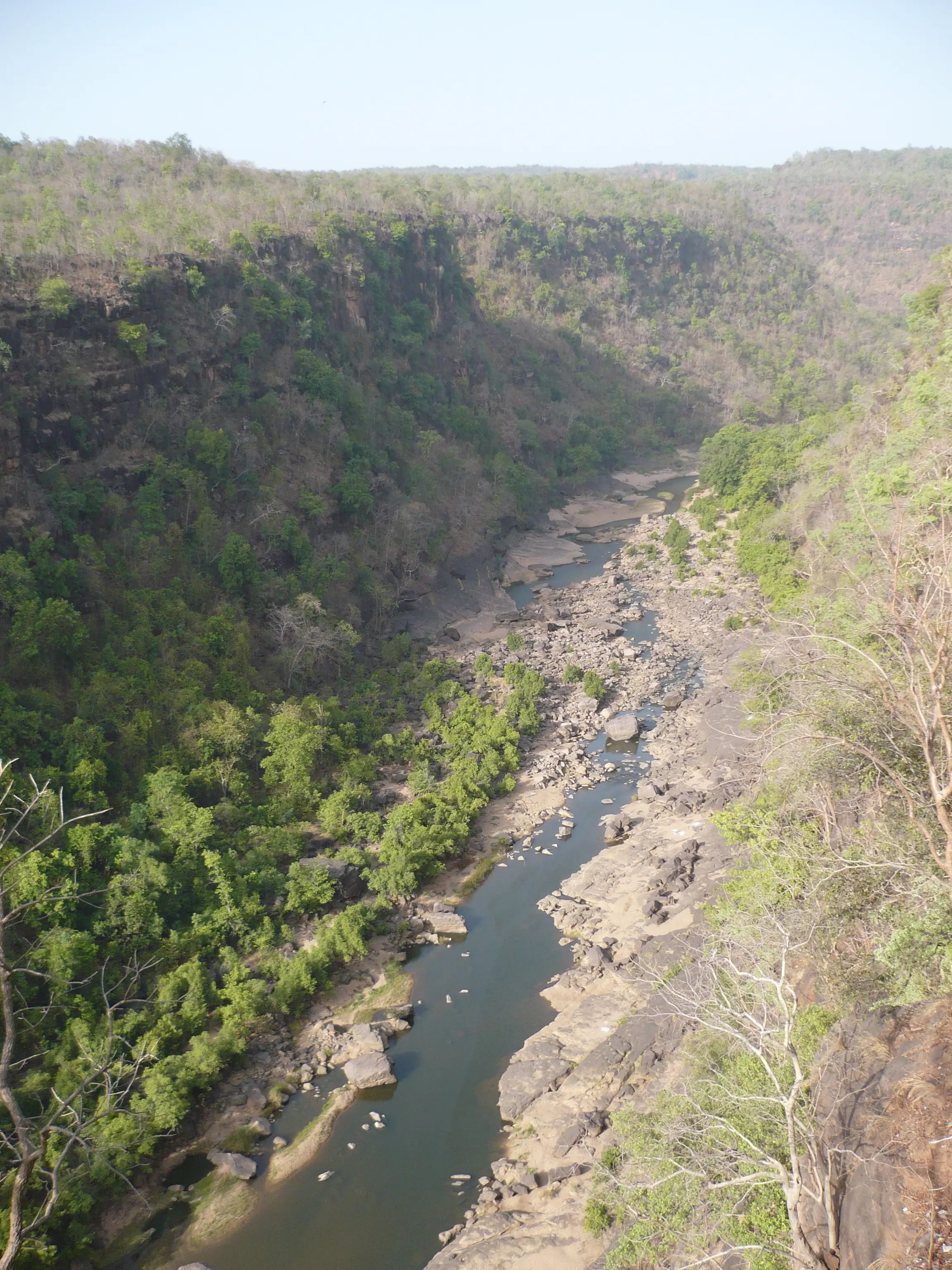 The Denwa river winding over rocks and sandbanks through a deep, dry-season forested valley in the Satpura hills