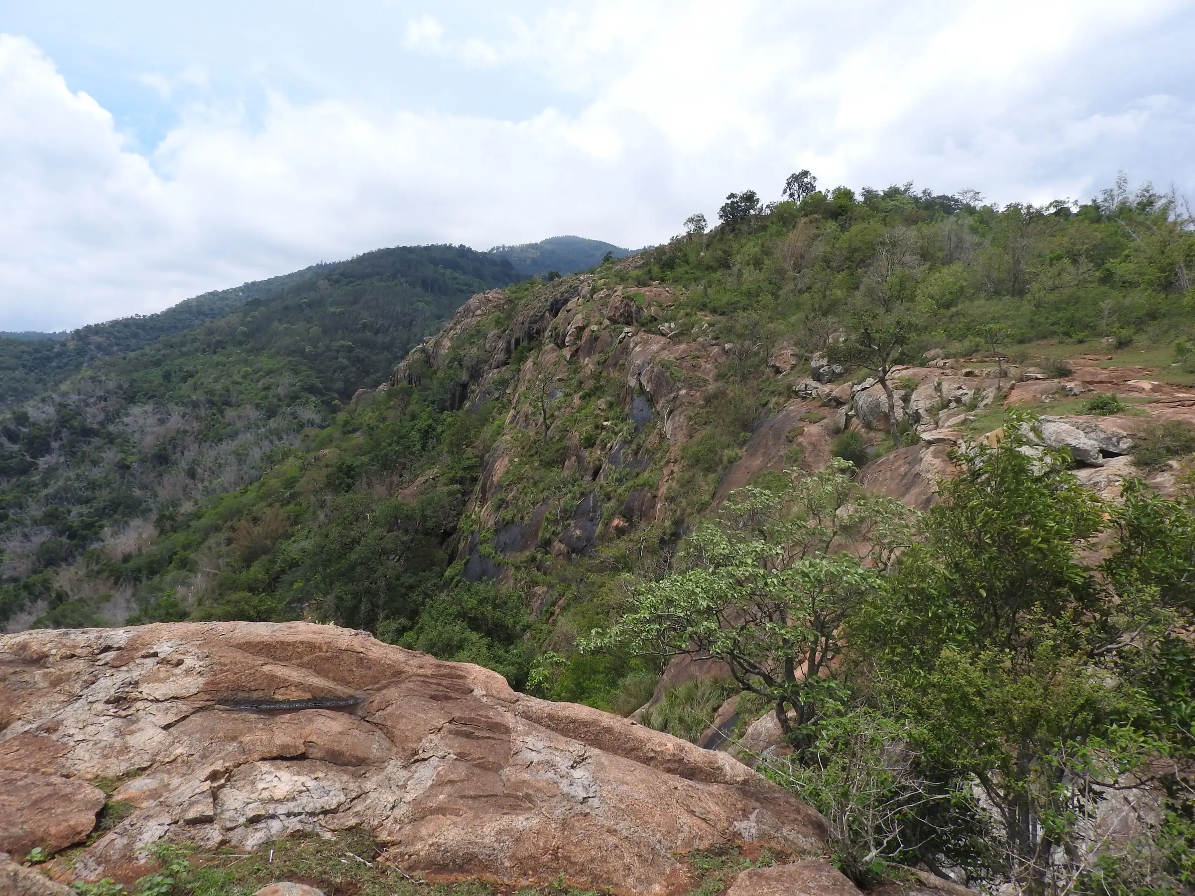 Rocky cliffs and forested slopes of the Shevaroy hills seen from a rock near Gundur, near the trek