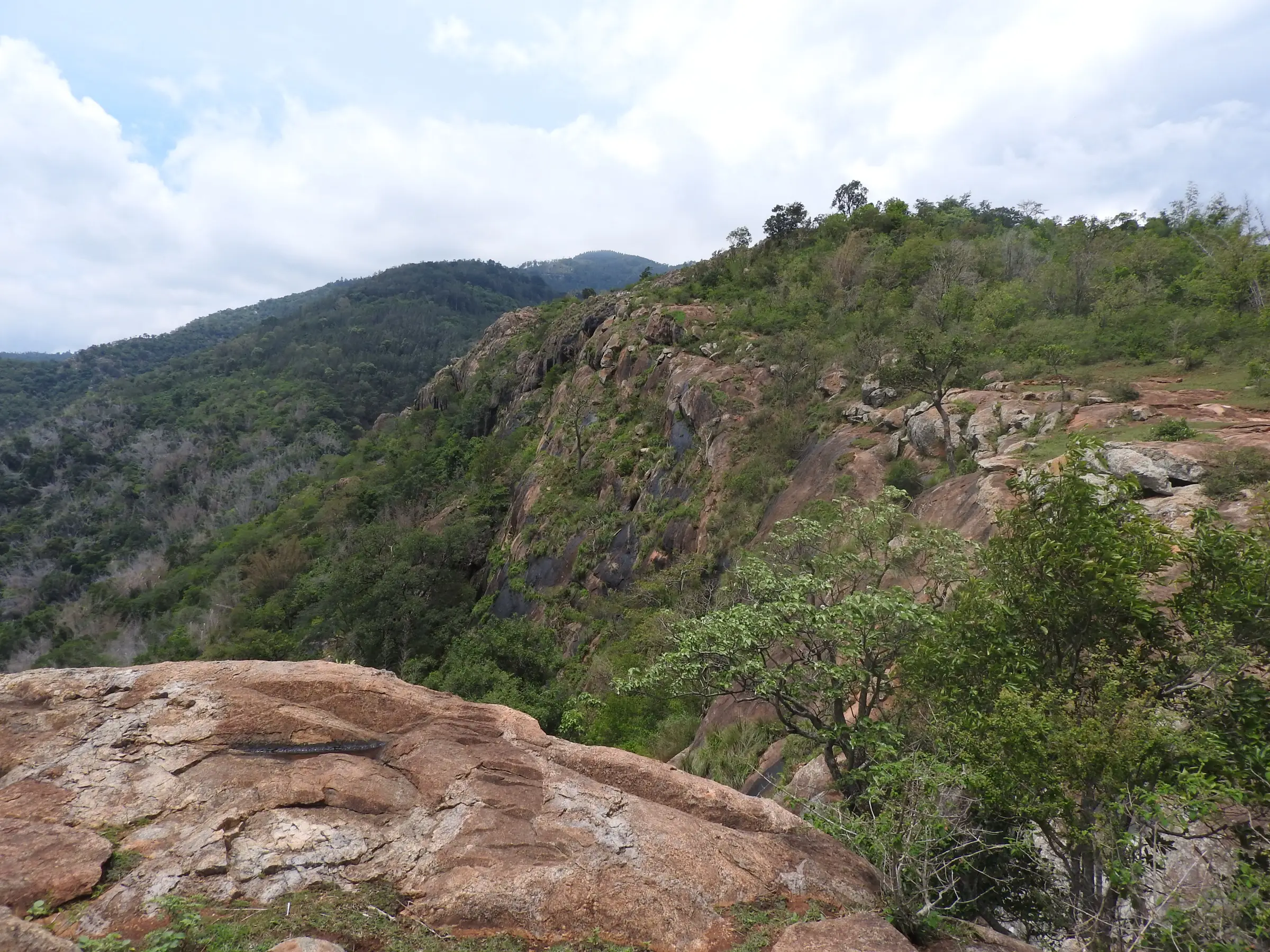 Rocky cliffs and forested slopes of the Shevaroy hills seen from a rock near Gundur, near the trek
