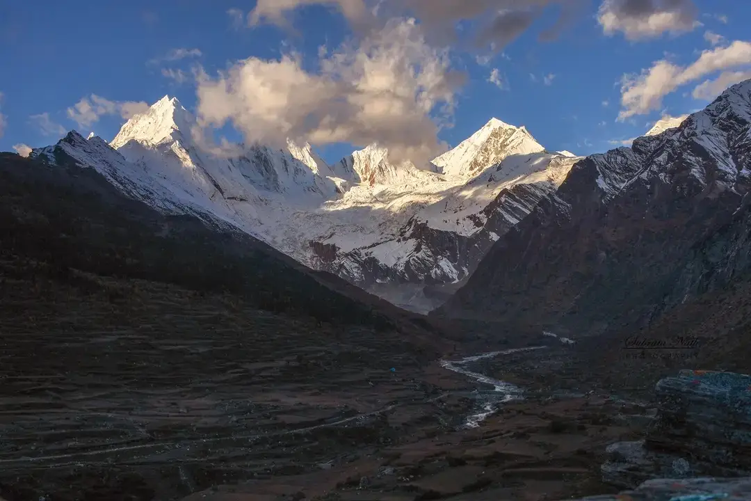 Panchachuli peaks and glacier at the head of the valley, seen above the fields and river at Dantu village in October