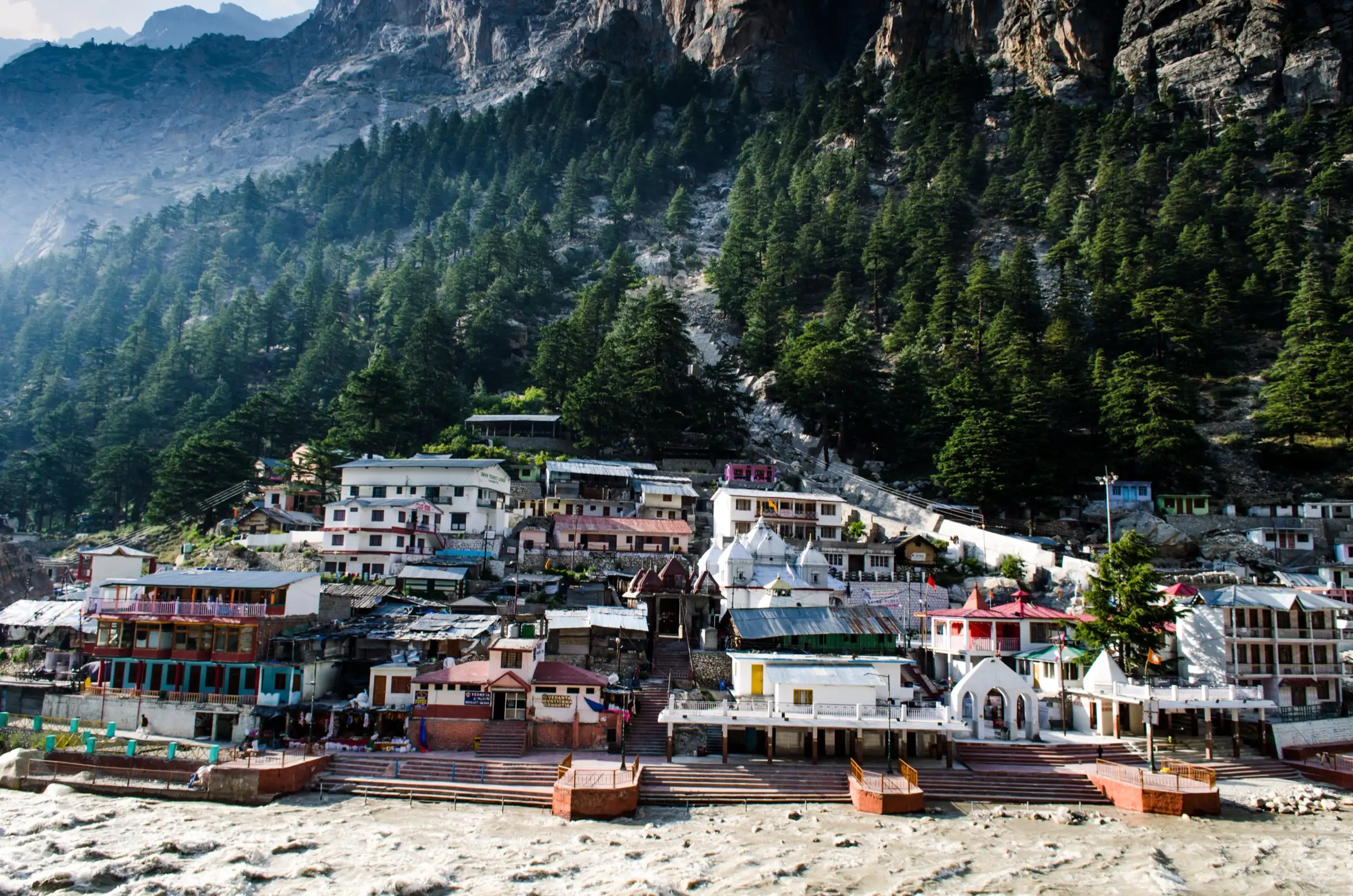 Gangotri town and temple on the banks of the Bhagirathi below pine-covered cliffs, the starting point of the trek