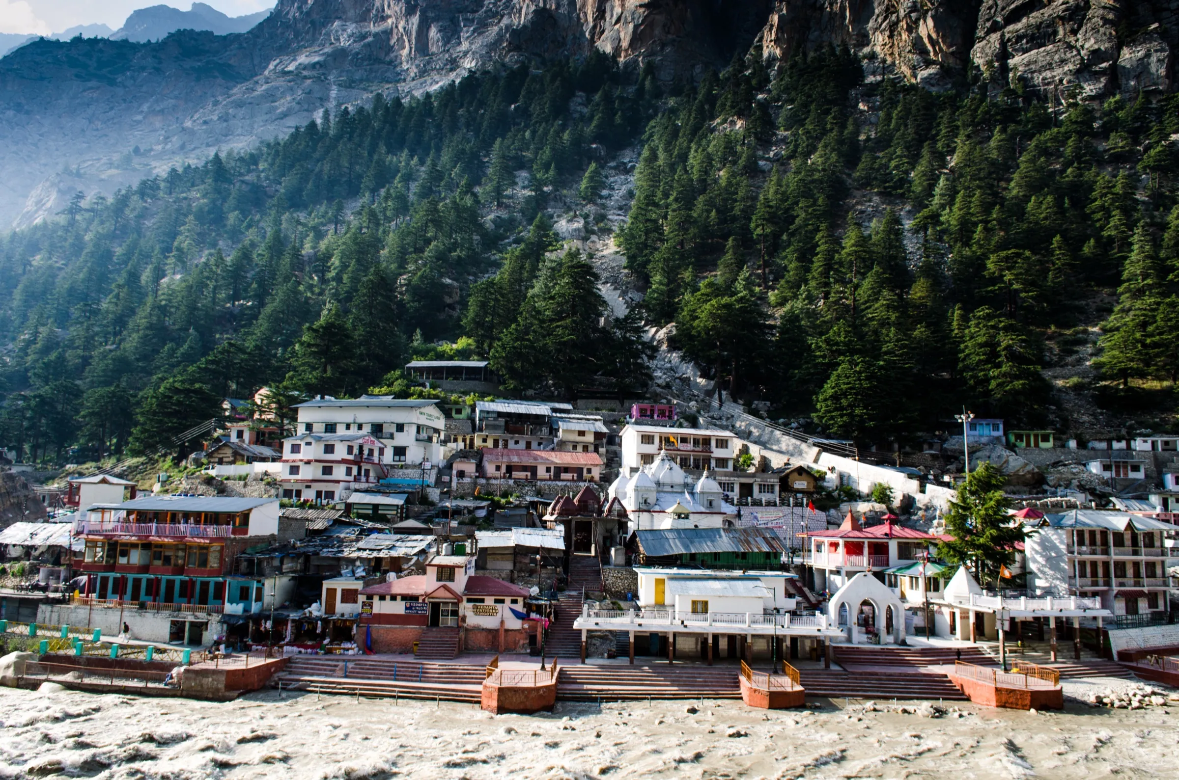 Gangotri town and temple on the banks of the Bhagirathi below pine-covered cliffs, the starting point of the trek