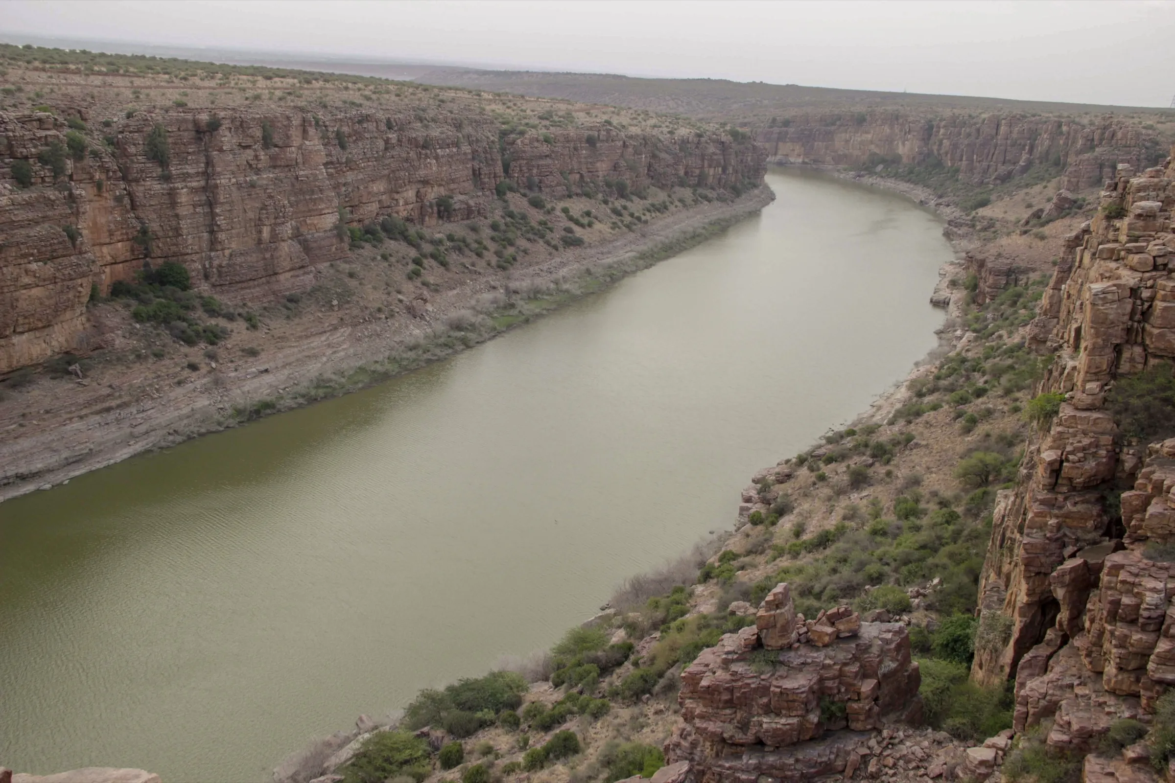 The Penna river winding between layered red quartzite cliffs of the Gandikota gorge, seen from the rim