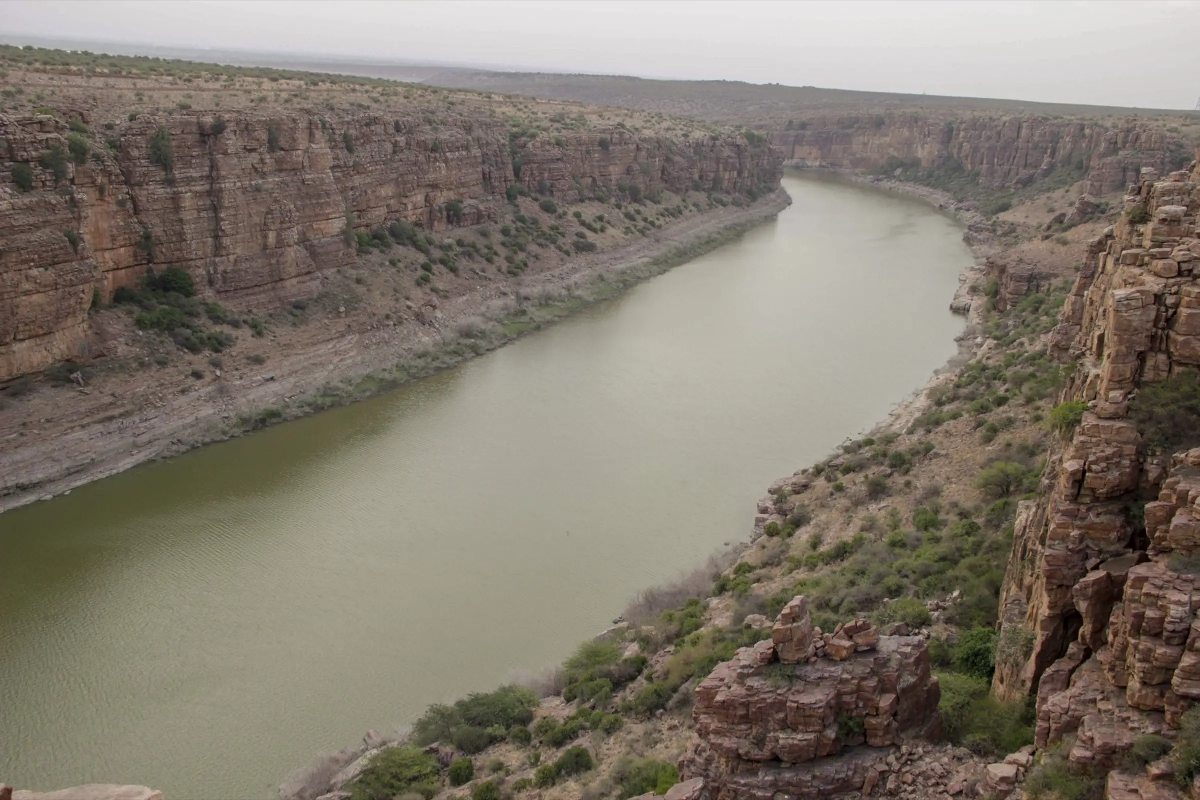 The Penna river winding between layered red quartzite cliffs of the Gandikota gorge, seen from the rim