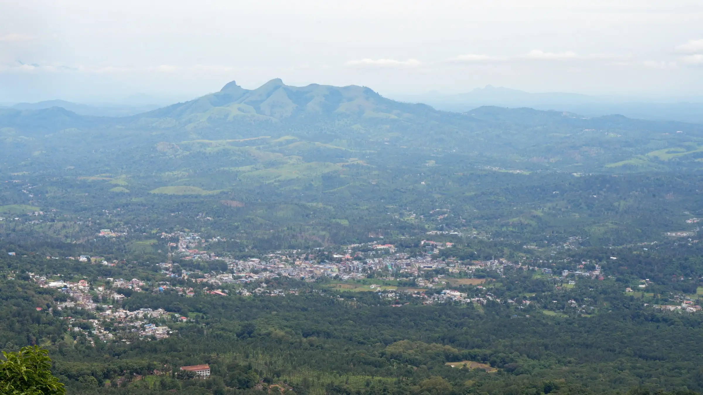 Gudalur town in the valley with Needle Rock and the hills west of town behind, seen from Valley View Point on NH 181, near the trek