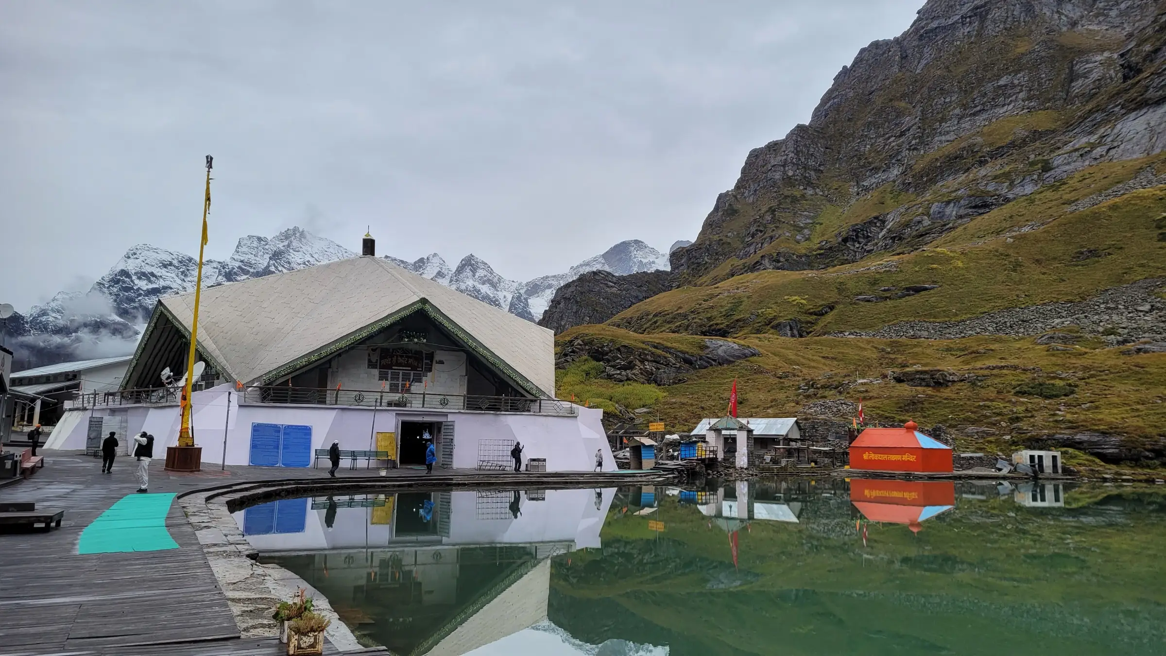 Hemkund Sahib gurudwara reflected in its glacial lake below snow-capped peaks