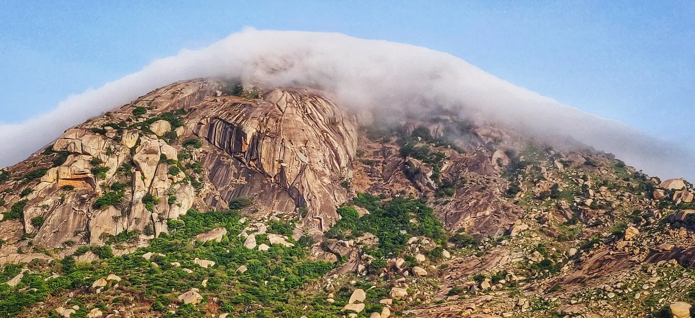 Cloud spilling over the granite slopes of Skandagiri, a neighbouring hill about 8 km south of Harihara Betta, seen from Muddenahalli (not the trek itself)