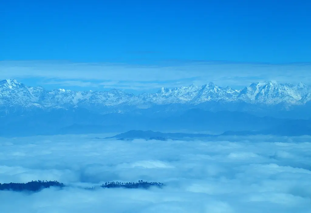 Snow-capped Kumaon Himalaya peaks rising above a sea of cloud, seen from Binsar