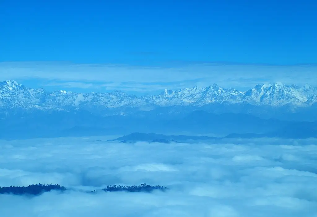 Snow-capped Kumaon Himalaya peaks rising above a sea of cloud, seen from Binsar