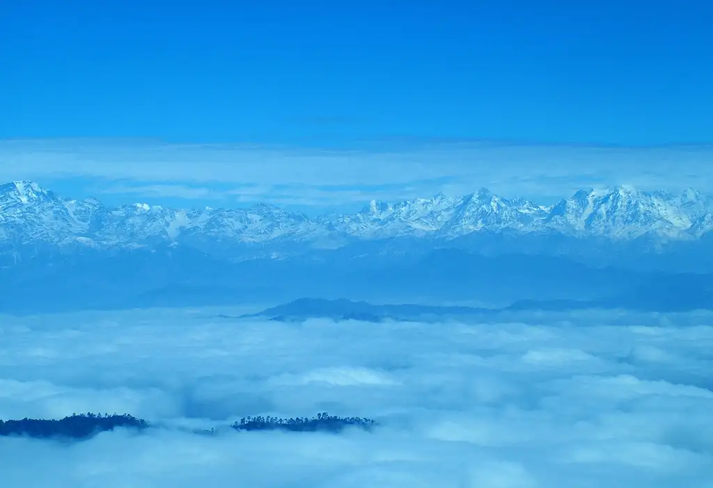 Snow-capped Kumaon Himalaya peaks rising above a sea of cloud, seen from Binsar