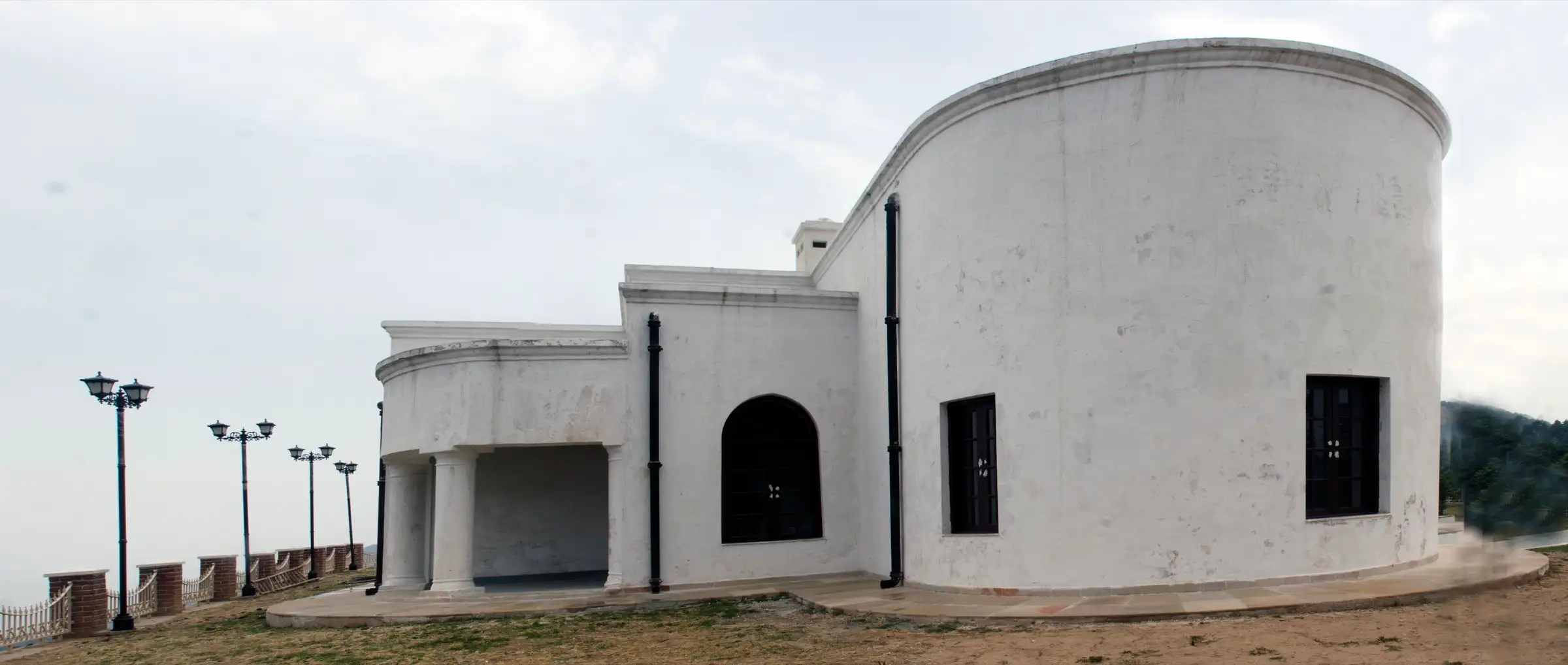 The restored white George Everest House with its curved wall and columned porch beside a fenced viewpoint terrace