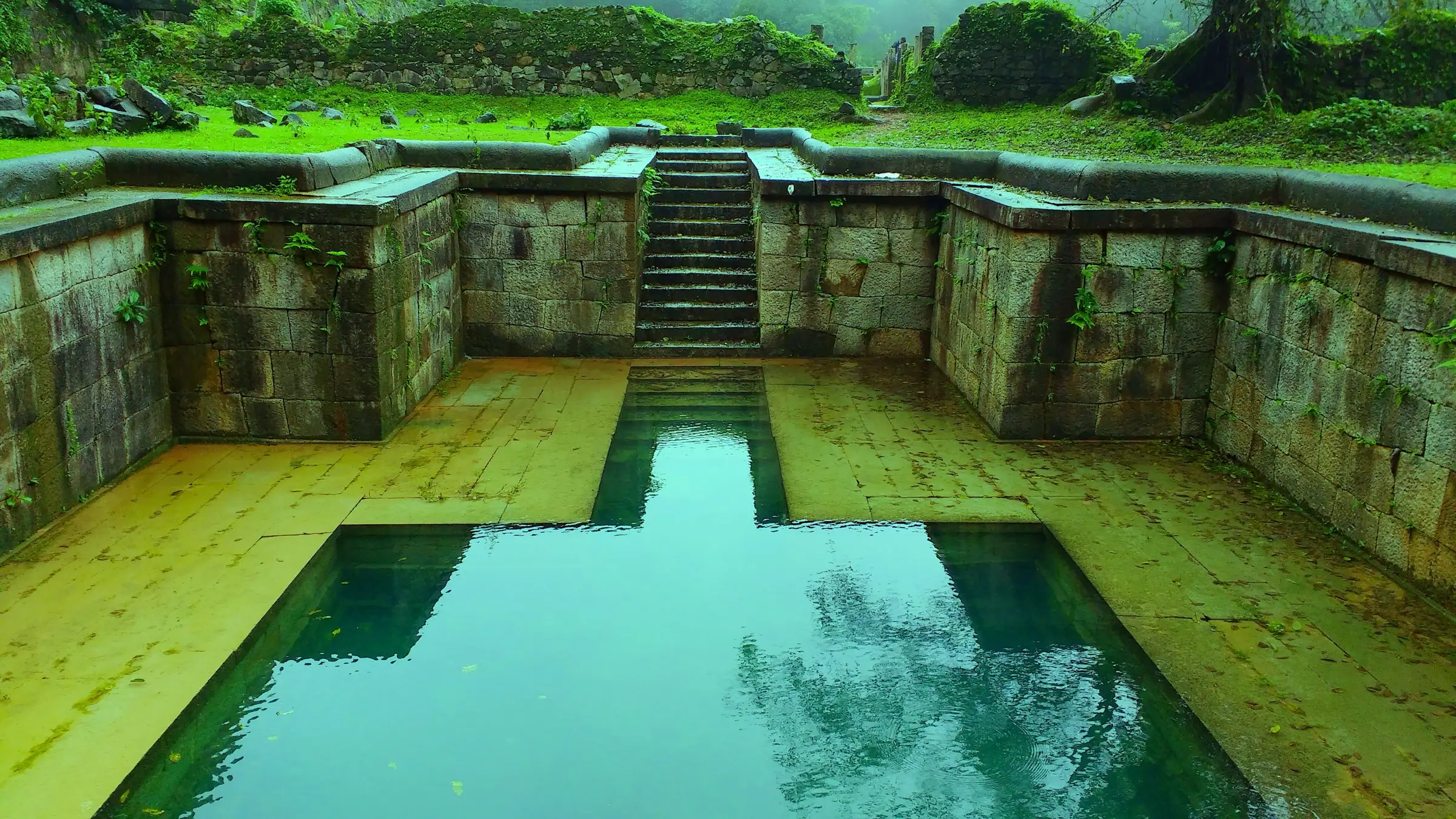 Stepped stone water tank with clear green water inside Kavaledurga Fort
