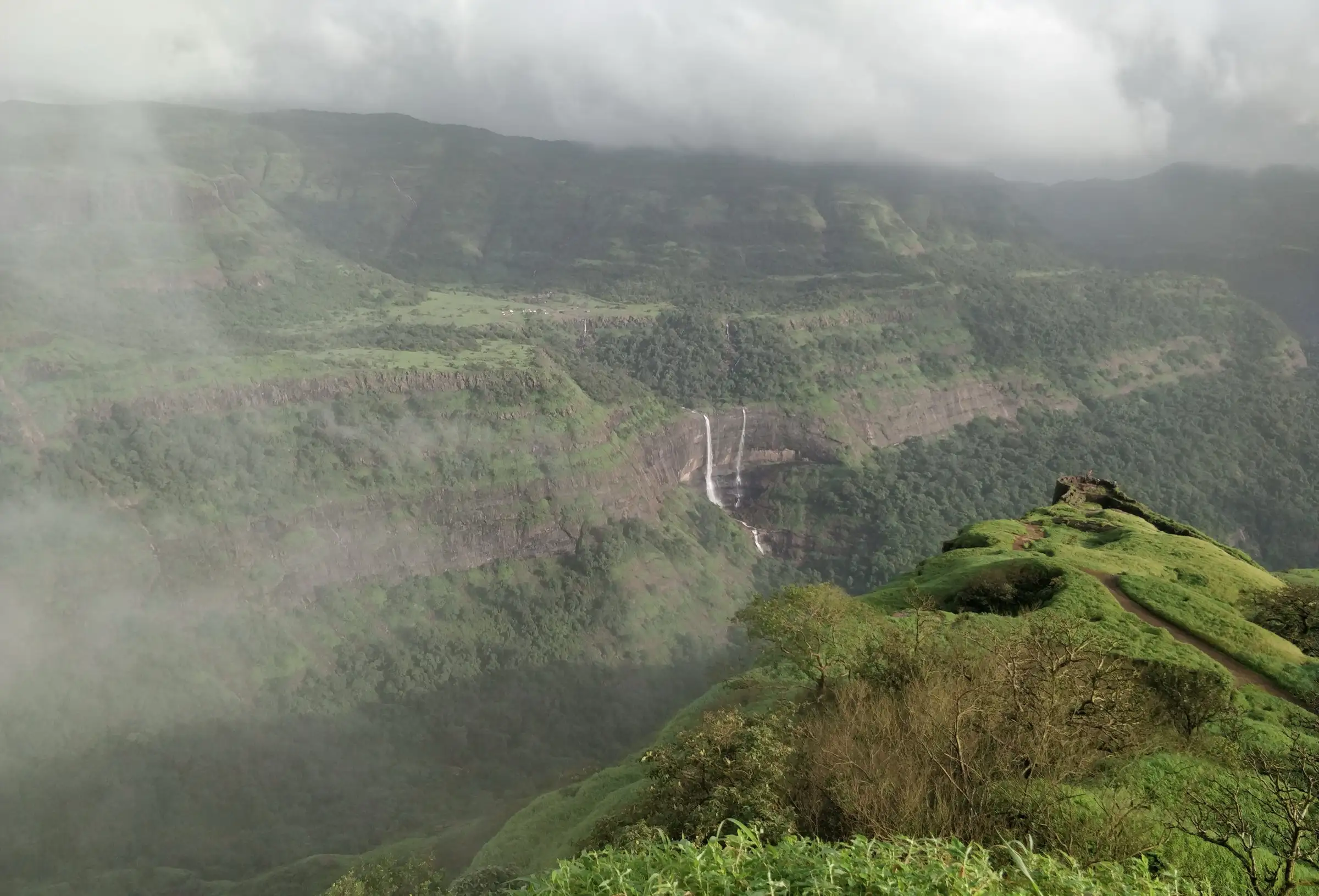 Kataldhar's twin streams falling from the plateau into the forested Ulhas valley, seen in monsoon from the Rajmachi side