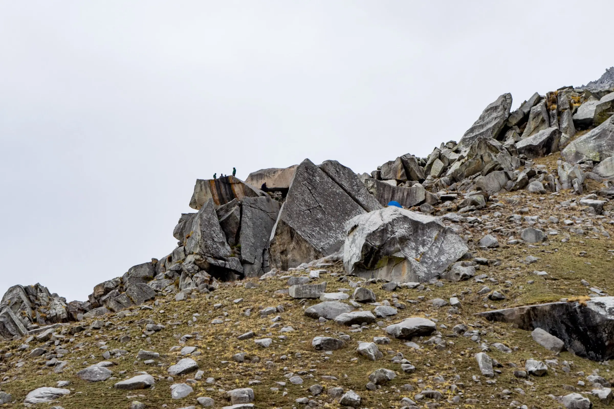 Trekkers standing on the giant boulders of Lahesh Cave, the base camp for Moon Peak