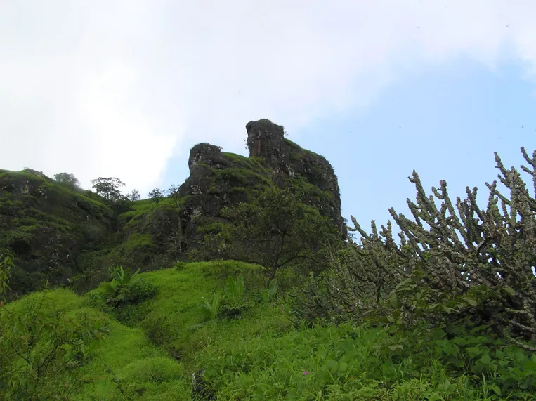 Rocky basalt pinnacles of Mahuli Fort rising above green monsoon slopes