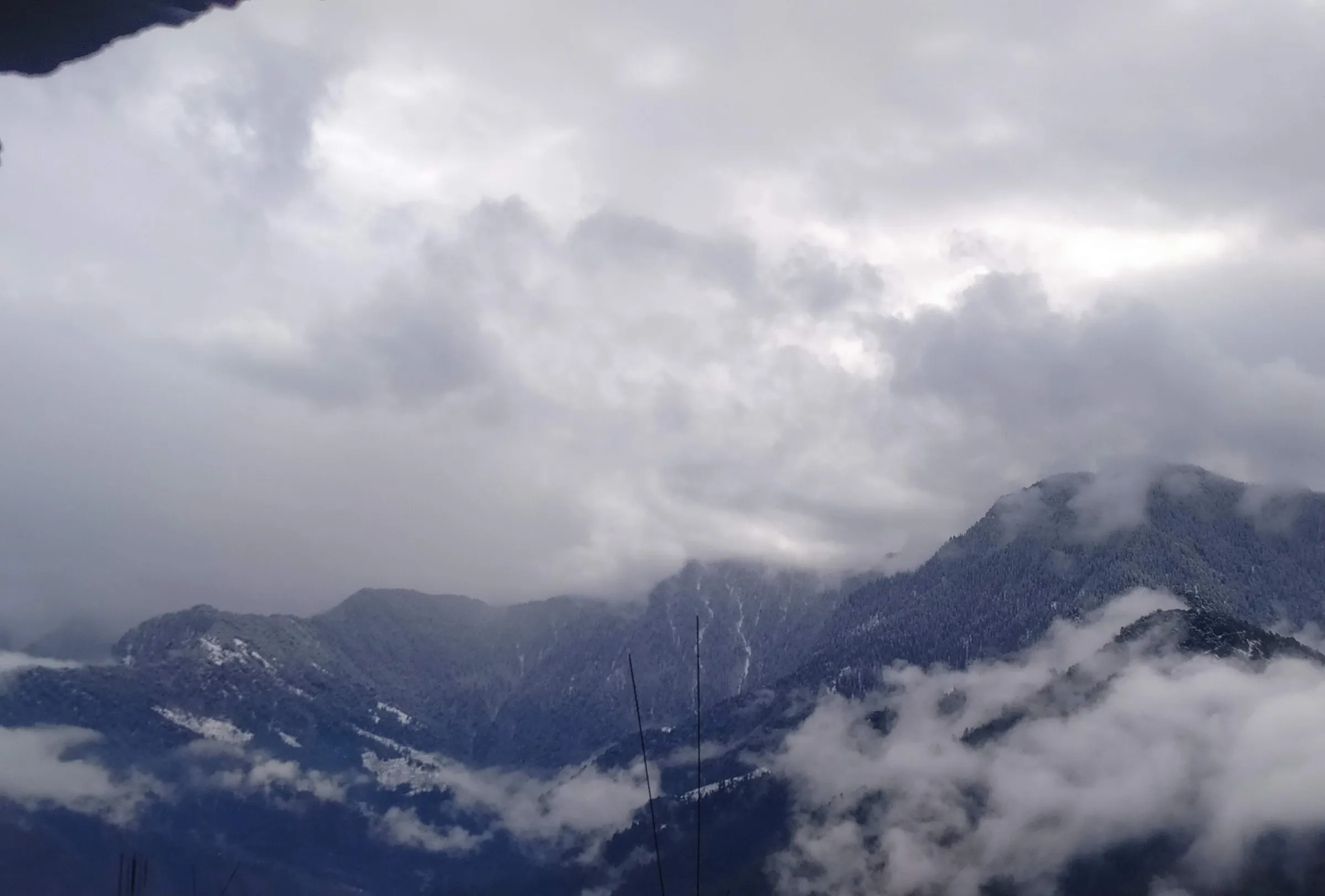 Snow-dusted, forested Mural Danda range half hidden in cloud, seen from Lalsa village near Rampur Bushahr