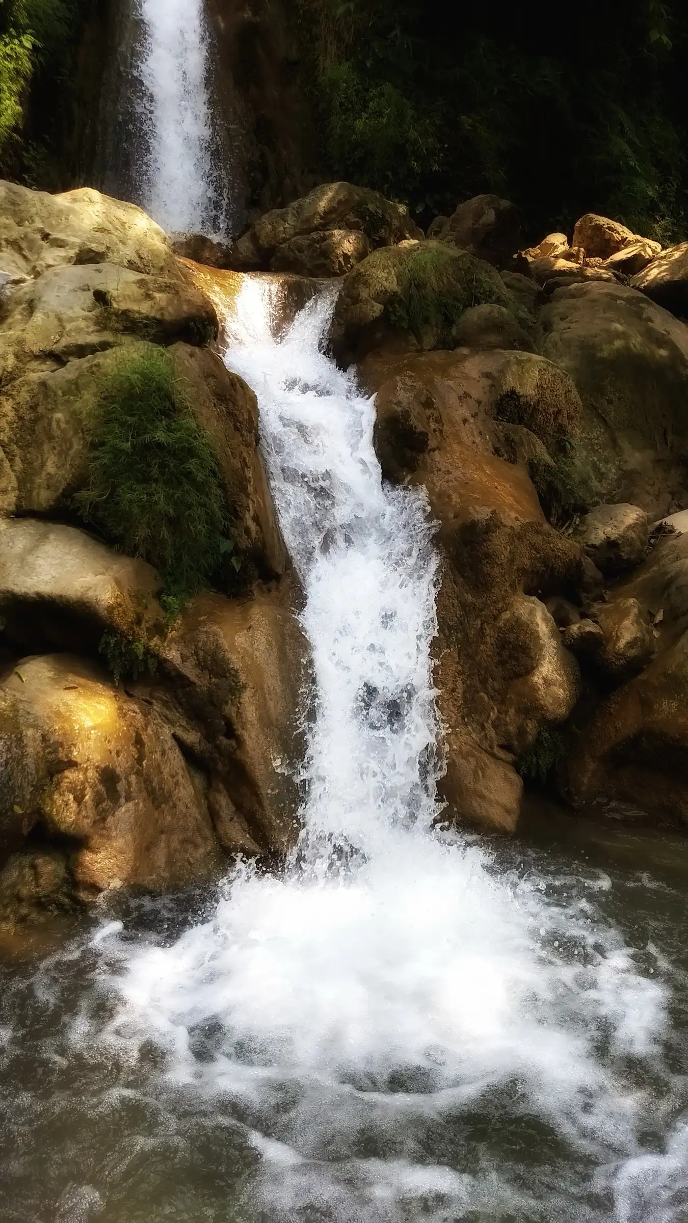 Neer Garh waterfall tumbling over golden rocks into a pool, on the trail between Tapovan and Kunjapuri
