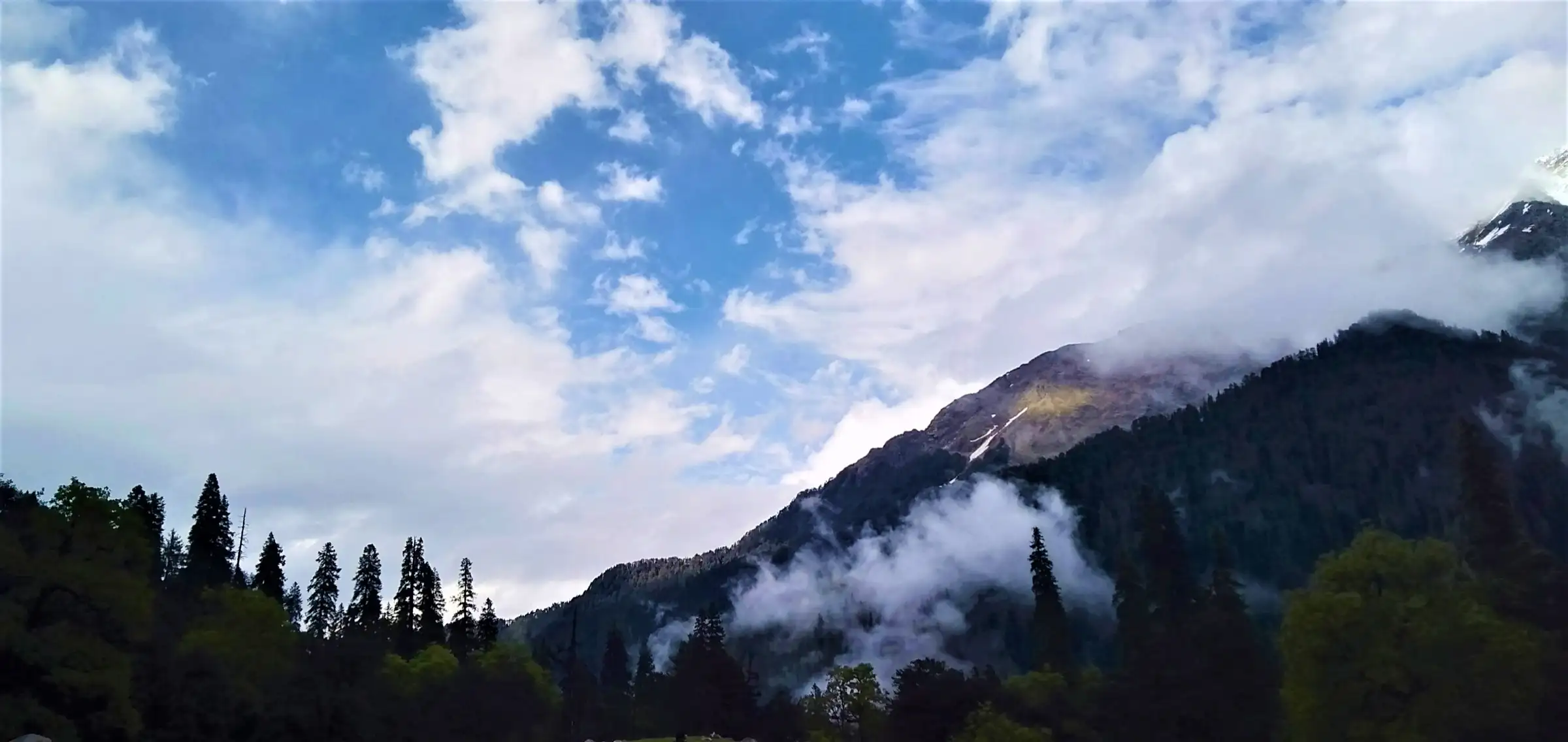 Forested ridges and cloud seen from the Padri campsite above Grahan, near the trek