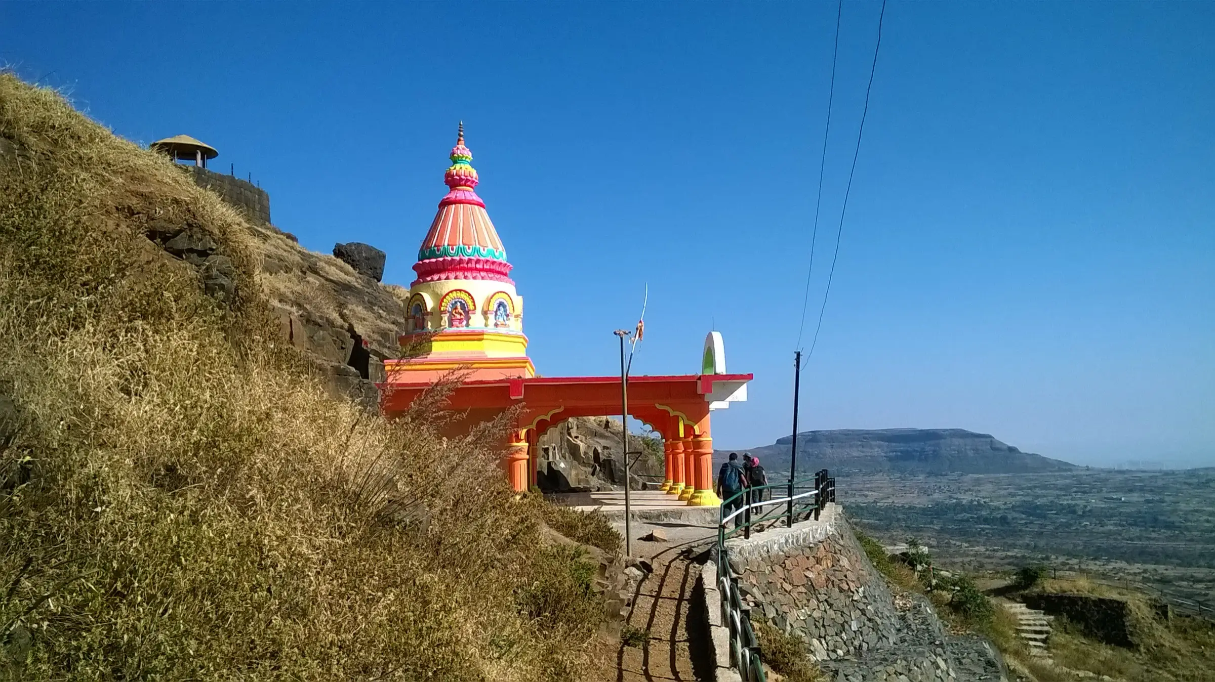 The brightly painted Devi Pattai temple on the stepped path up Patta Fort, with trekkers walking past