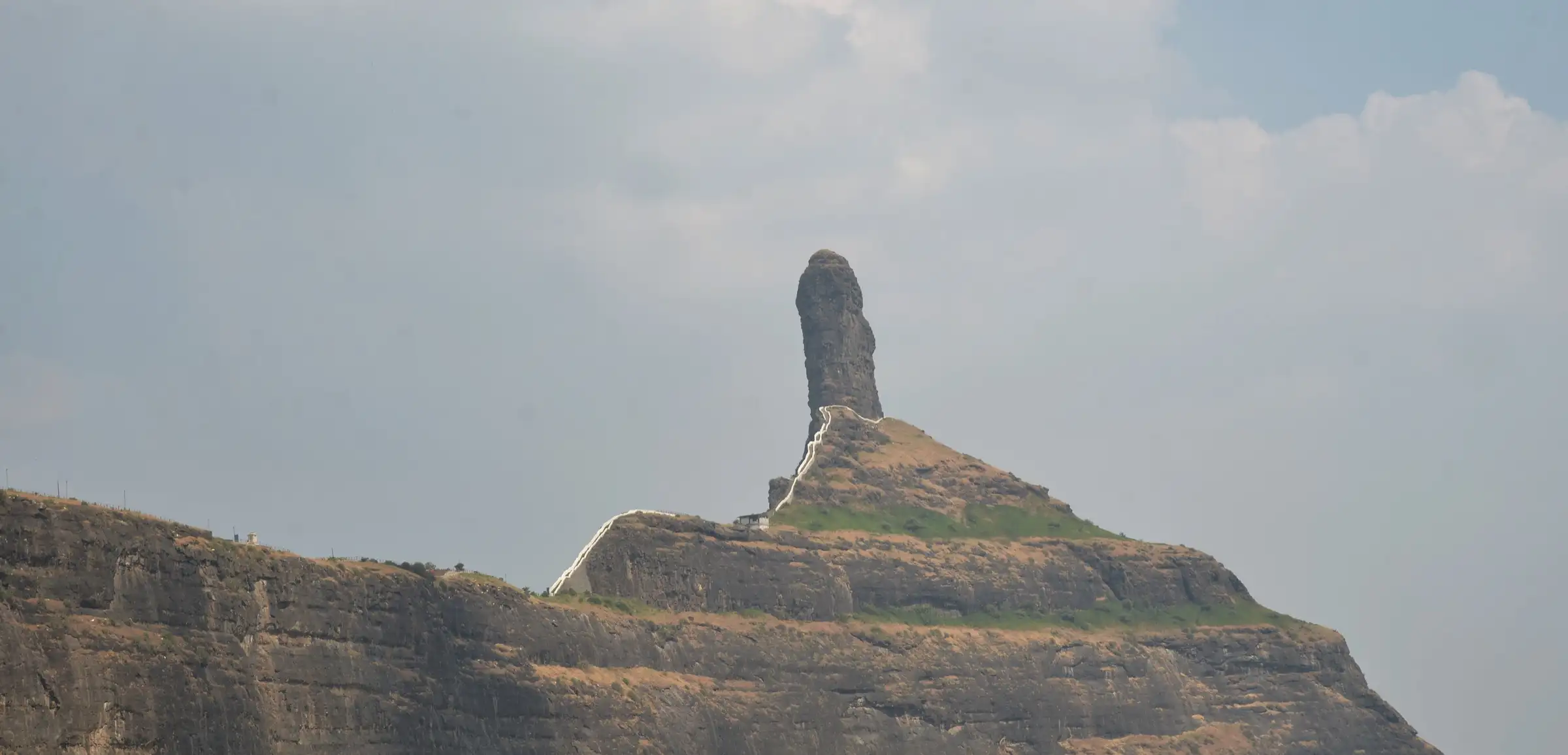 A Mangi Tungi rock pinnacle with the white-railed stairway climbing the ridge to its base