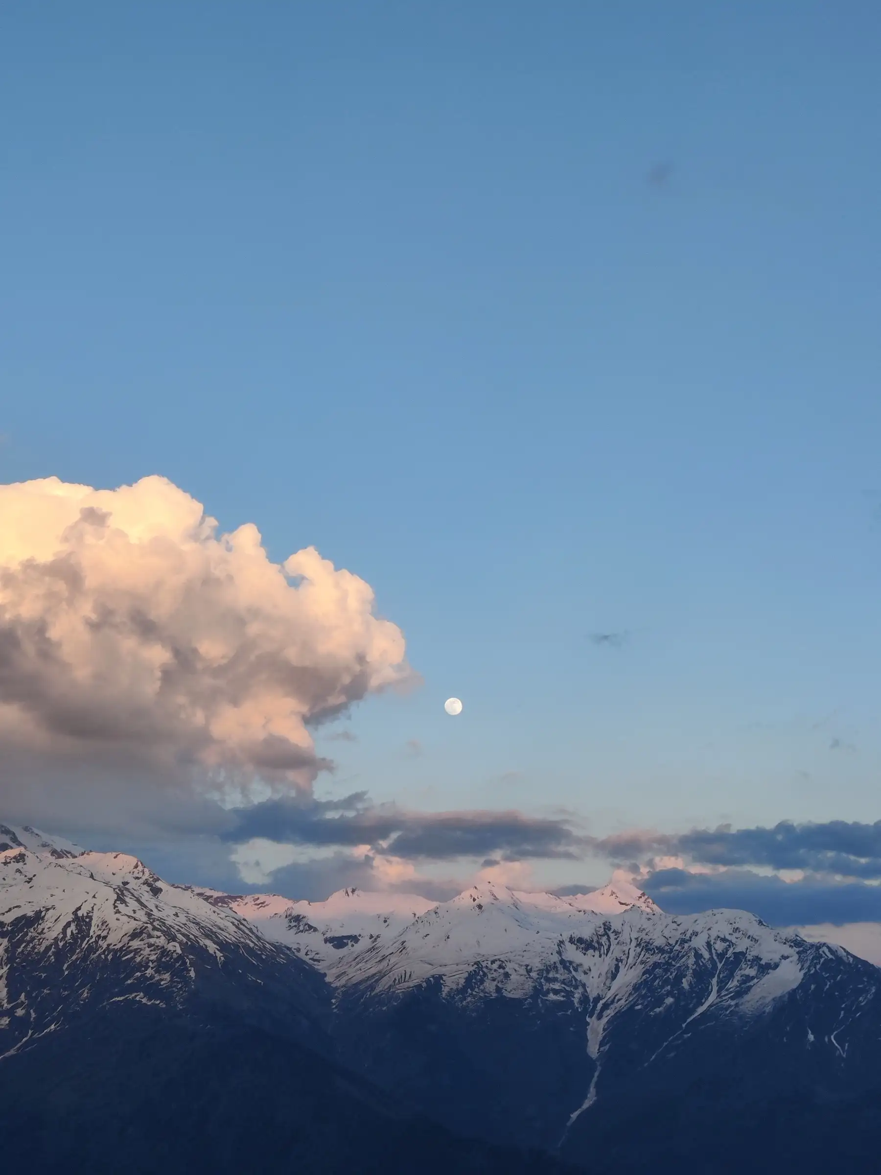 Evening light on snow-capped peaks with a rising moon, seen from the Rani Sui Lake trek above Manali