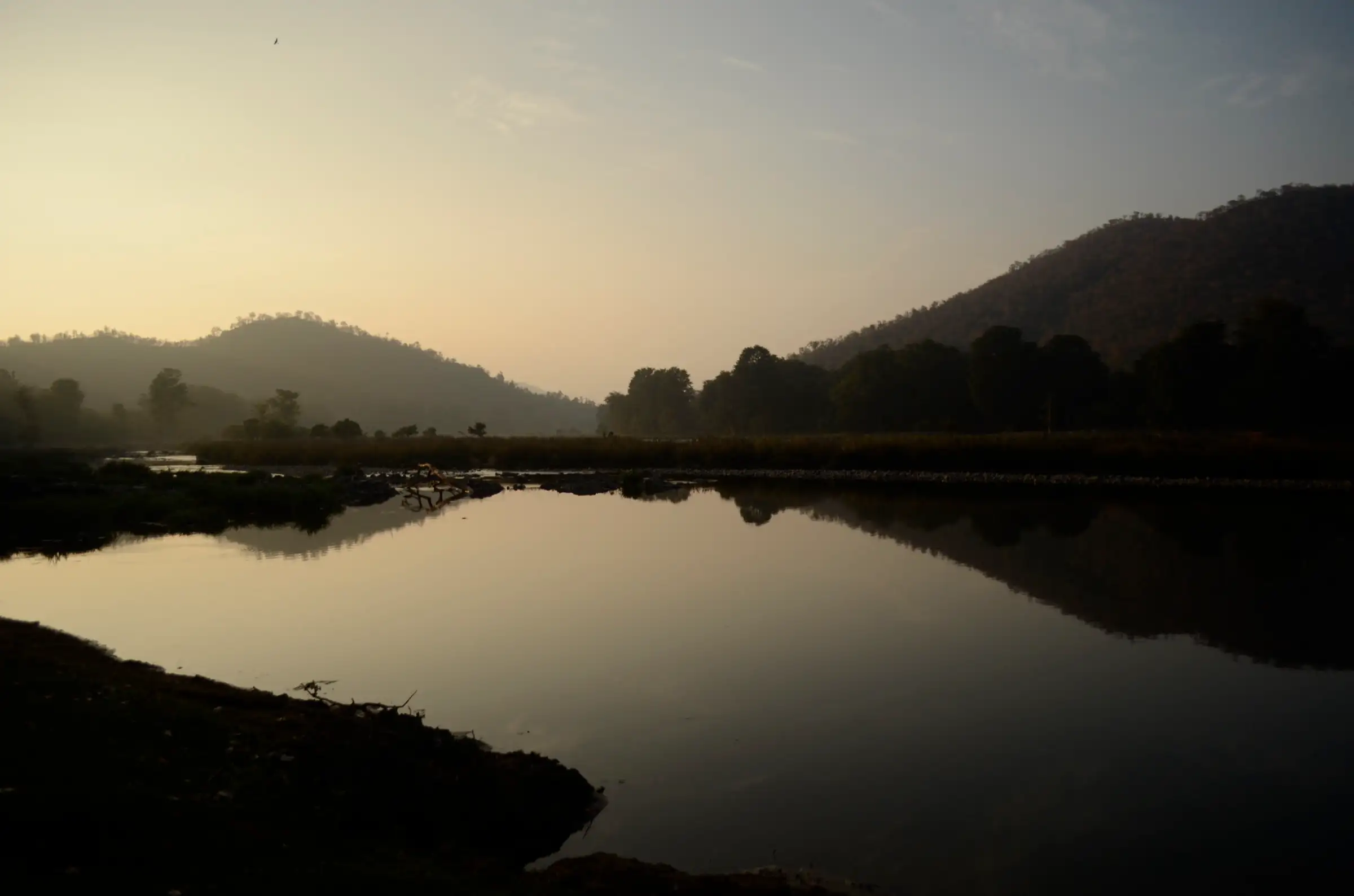 The Kaveri river near Biligundlu at dawn, with still water reflecting the forested hills