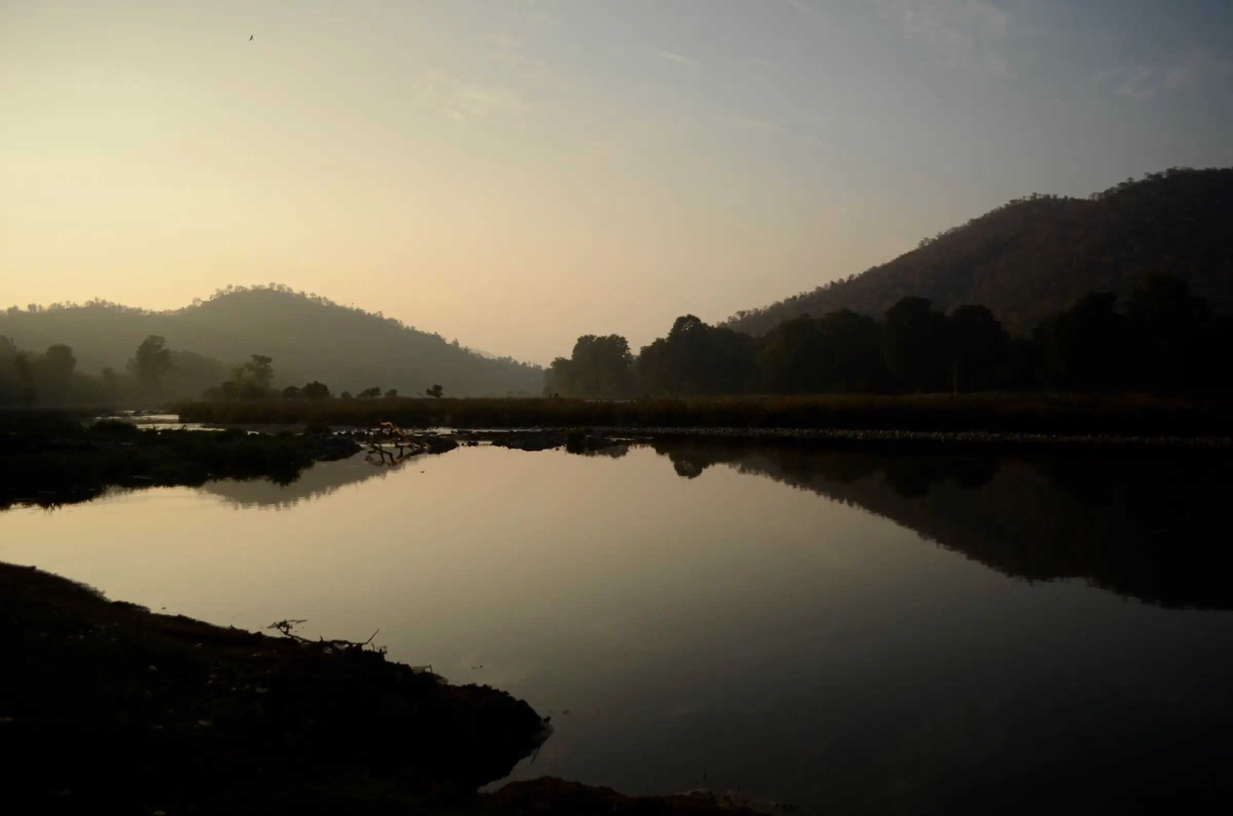 The Kaveri river near Biligundlu at dawn, with still water reflecting the forested hills