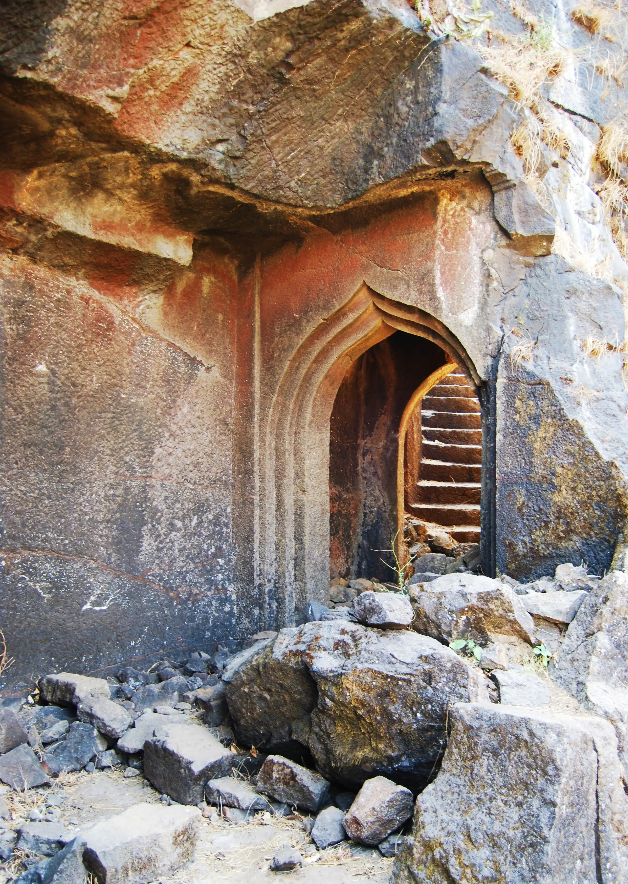 Arched gateway carved into the rock at Hadsar Fort, with rock-cut steps visible beyond it