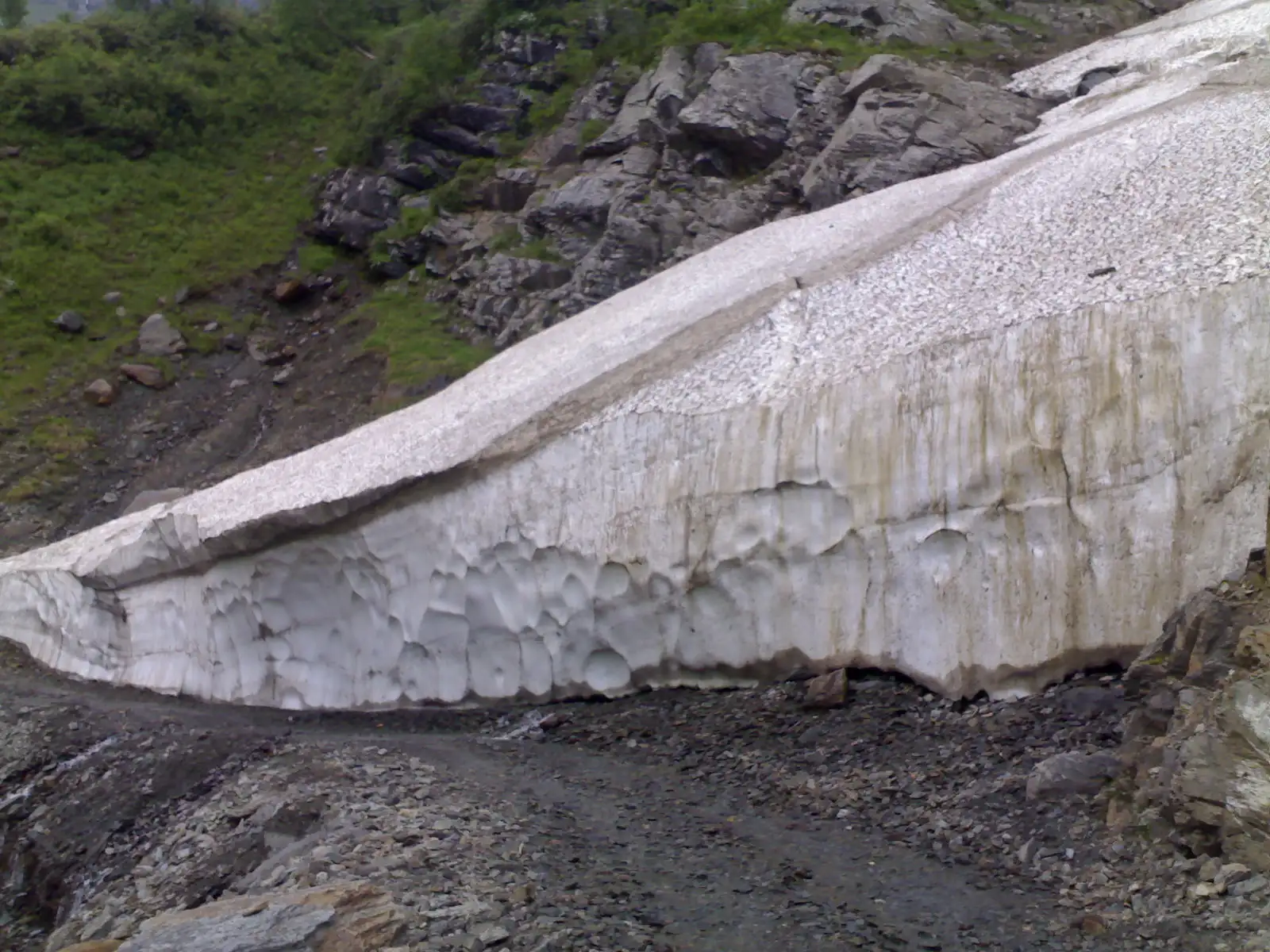 Wall of old snow and glacier ice beside the stony track at Satrundi, below Sach Pass