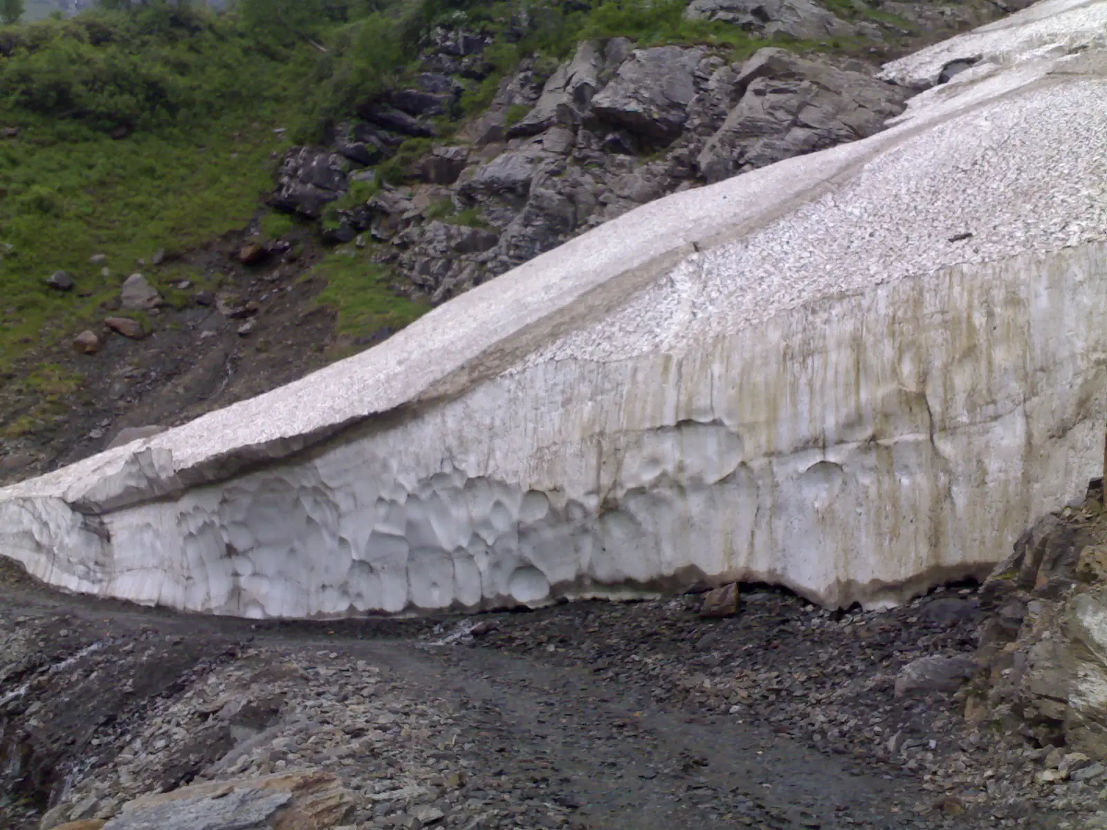 Wall of old snow and glacier ice beside the stony track at Satrundi, below Sach Pass