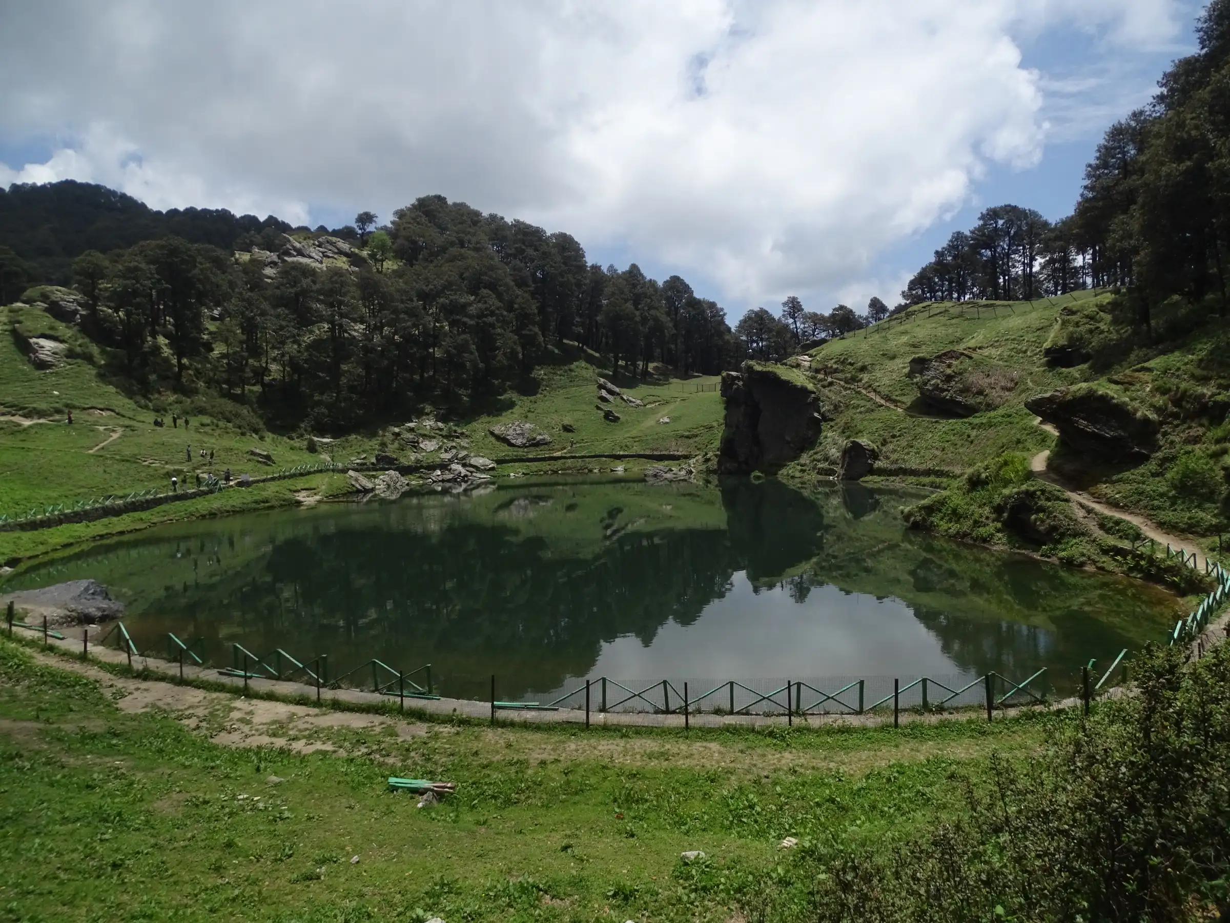 Serolsar Lake ringed by oak and conifer forest, the first camp on the Lambri trek from Jalori Pass