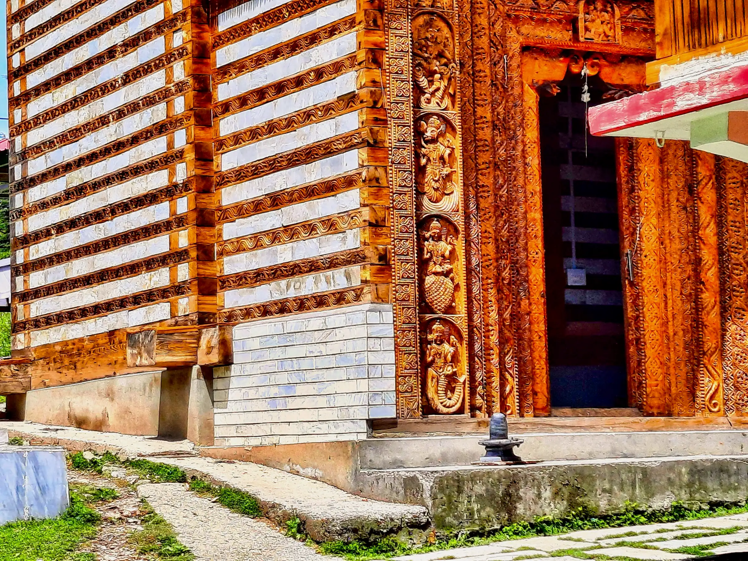 Carved wooden doorway and stone-and-timber wall of the Shangchul Mahadev temple at Shangarh