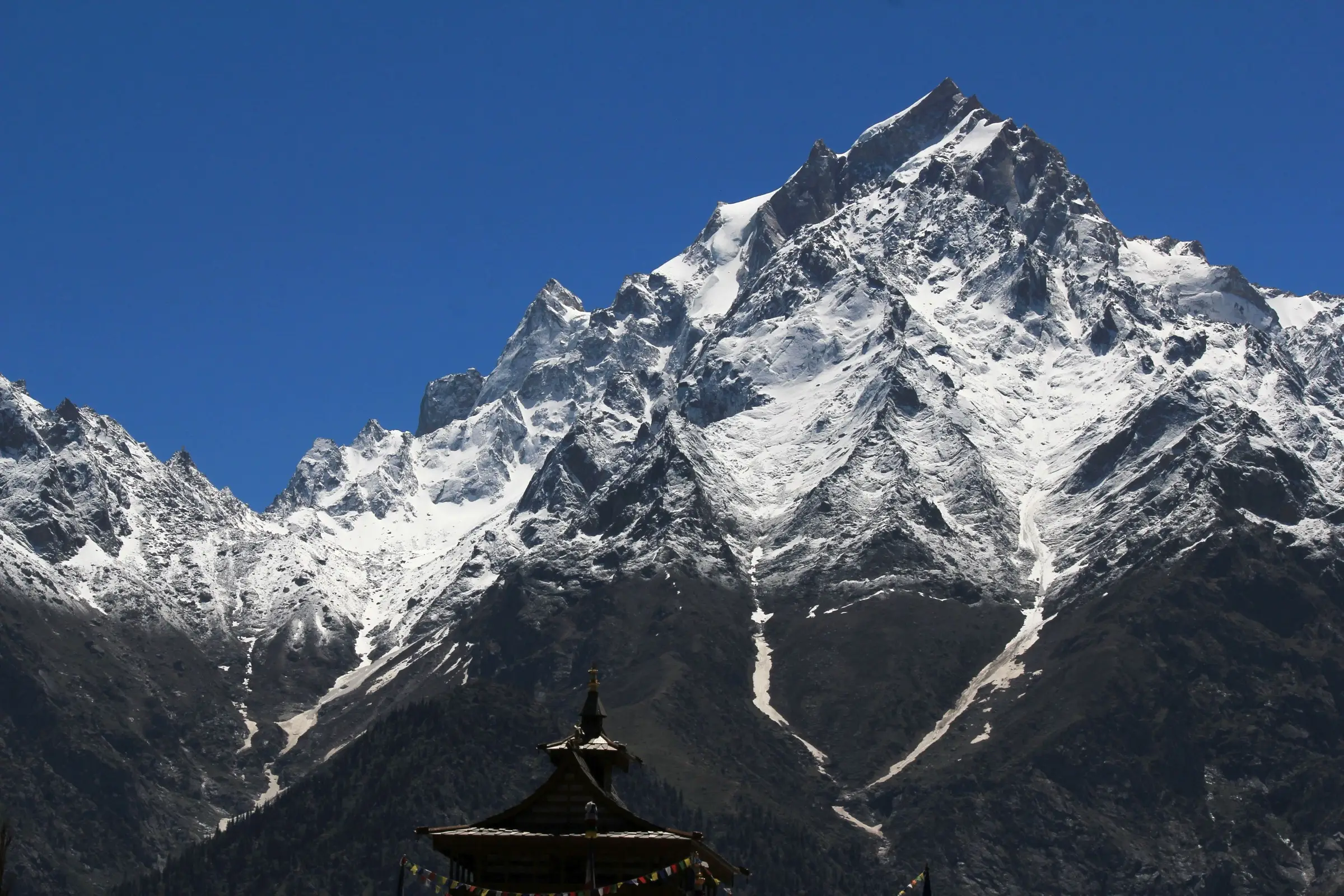Snowy Kinner Kailash range seen from Kalpa, with the top of the Kalpa temple roof in the foreground