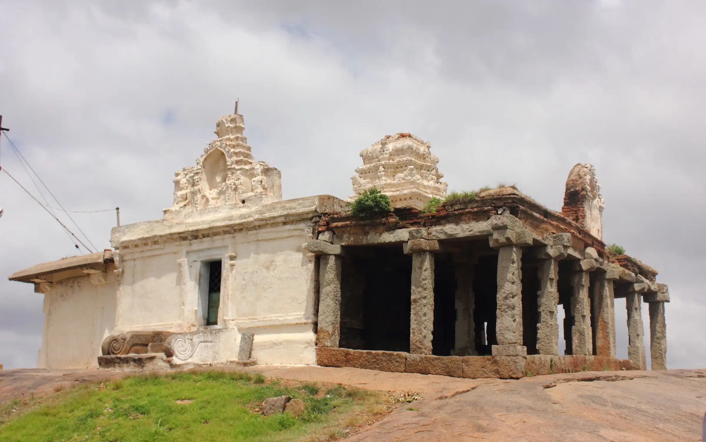 White-washed Shankareshwara temple with a pillared mandapa on the rocky summit of Hutridurga