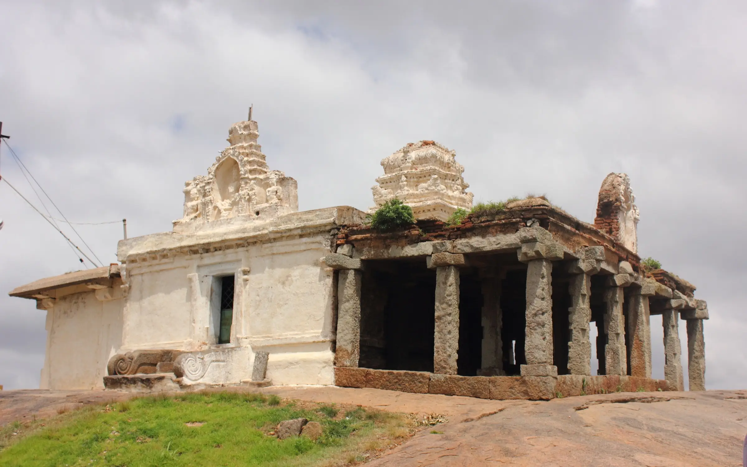 White-washed Shankareshwara temple with a pillared mandapa on the rocky summit of Hutridurga