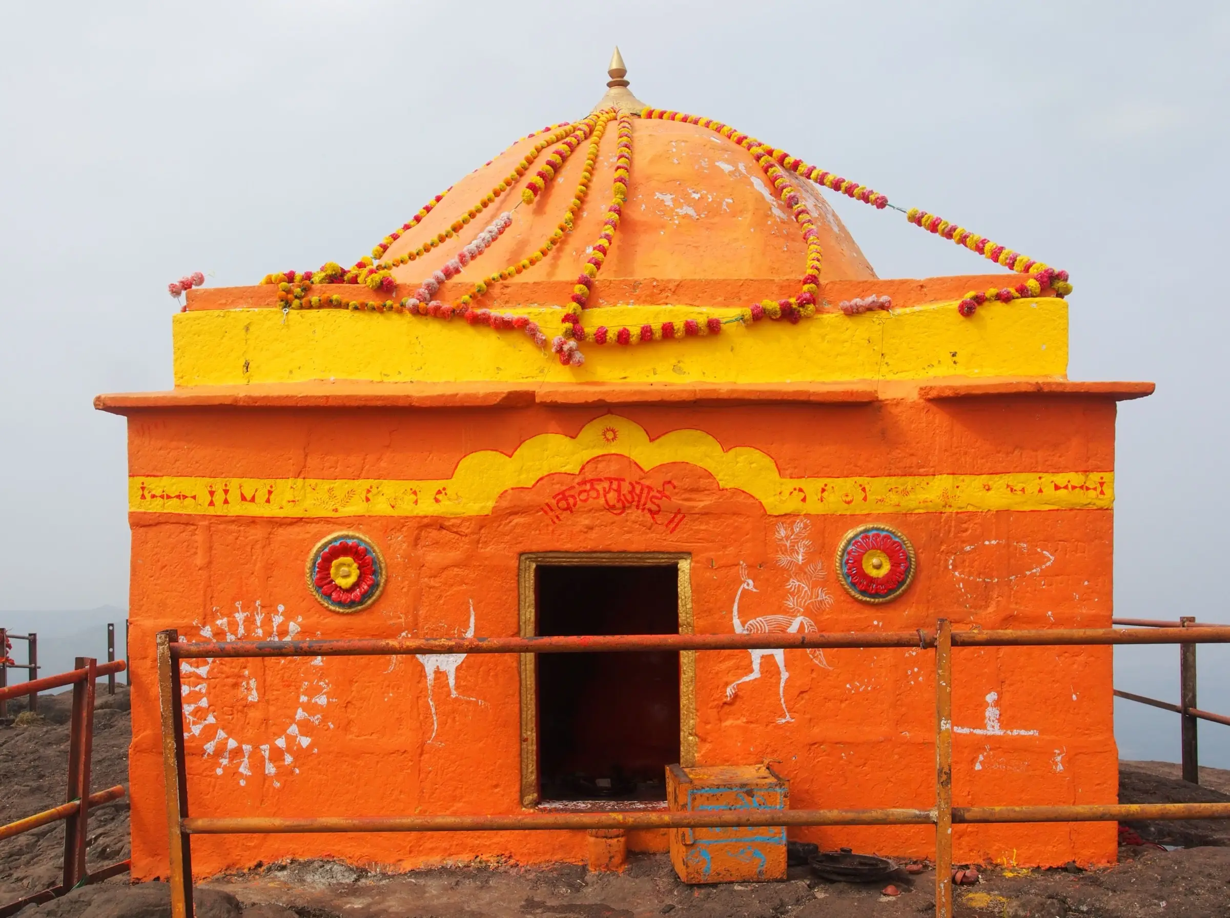 Orange Kalsubai Devi temple with marigold garlands on the summit