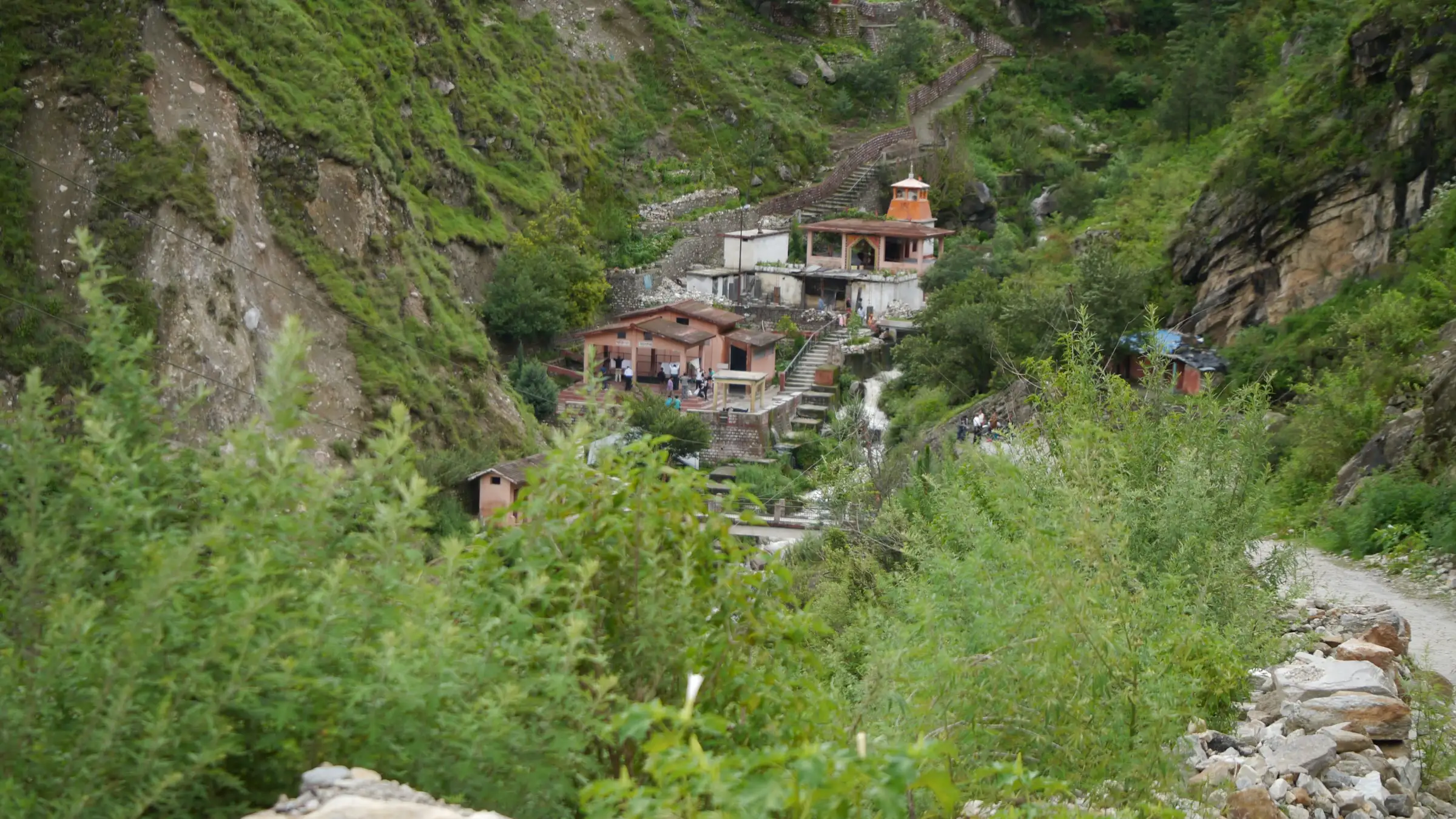 Houses and a small temple in a steep green side valley at Tapovan, about 3 km below Saldhar where the walk to Bhavishya Badri begins