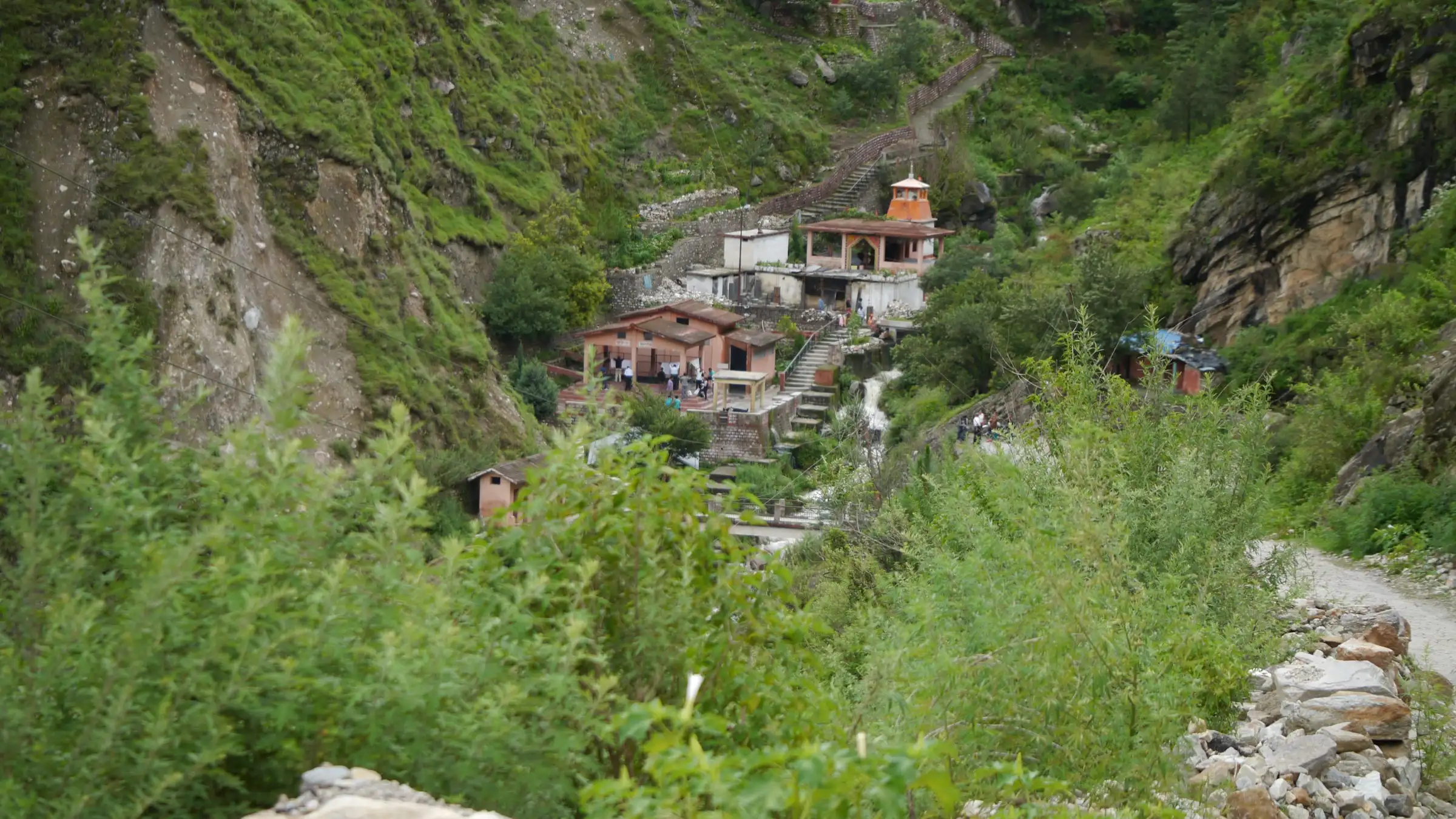 Houses and a small temple in a steep green side valley at Tapovan, about 3 km below Saldhar where the walk to Bhavishya Badri begins