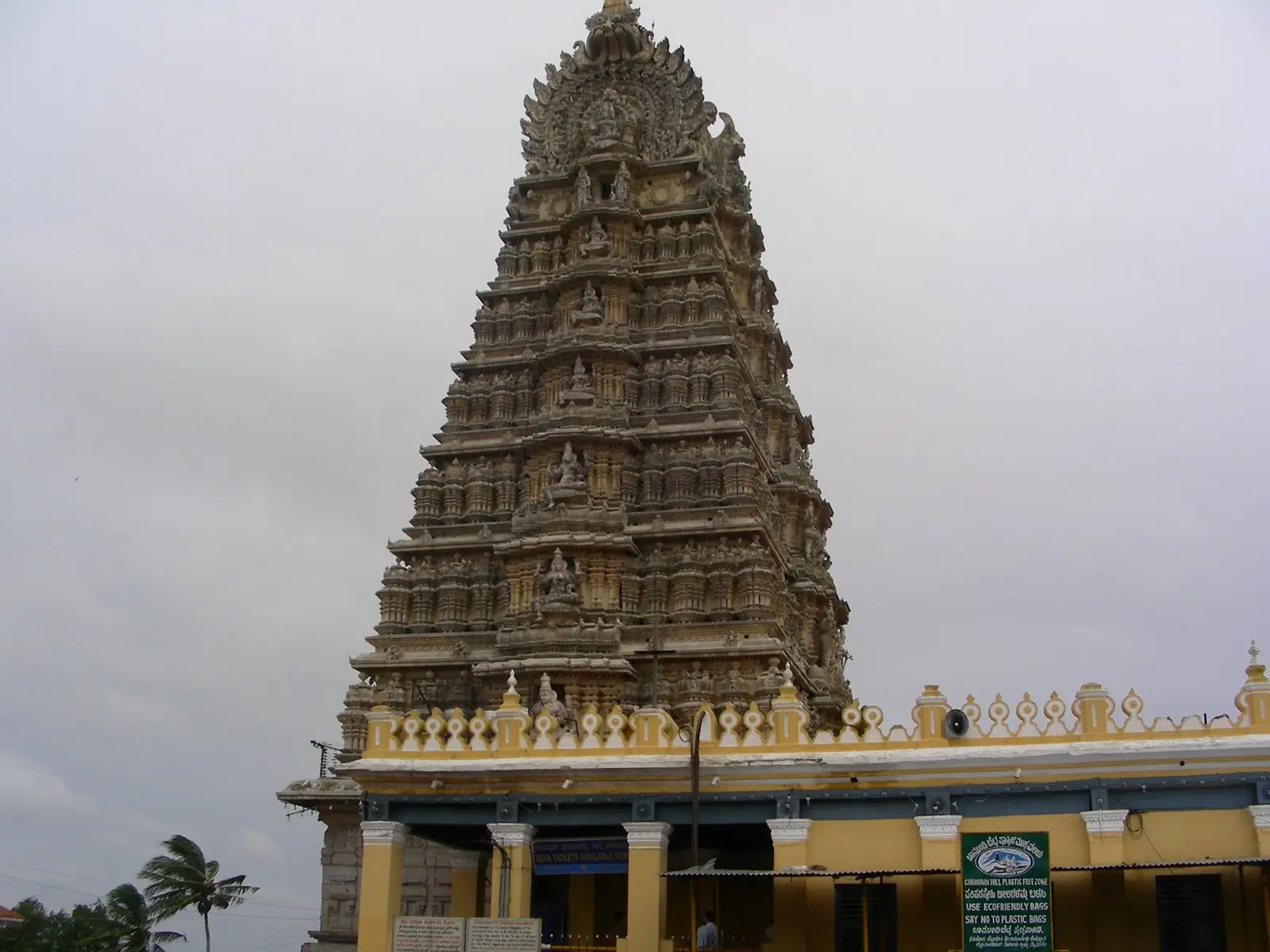 The carved seven-tiered gopuram of the Sri Chamundeshwari Temple on top of Chamundi Hill under a grey sky